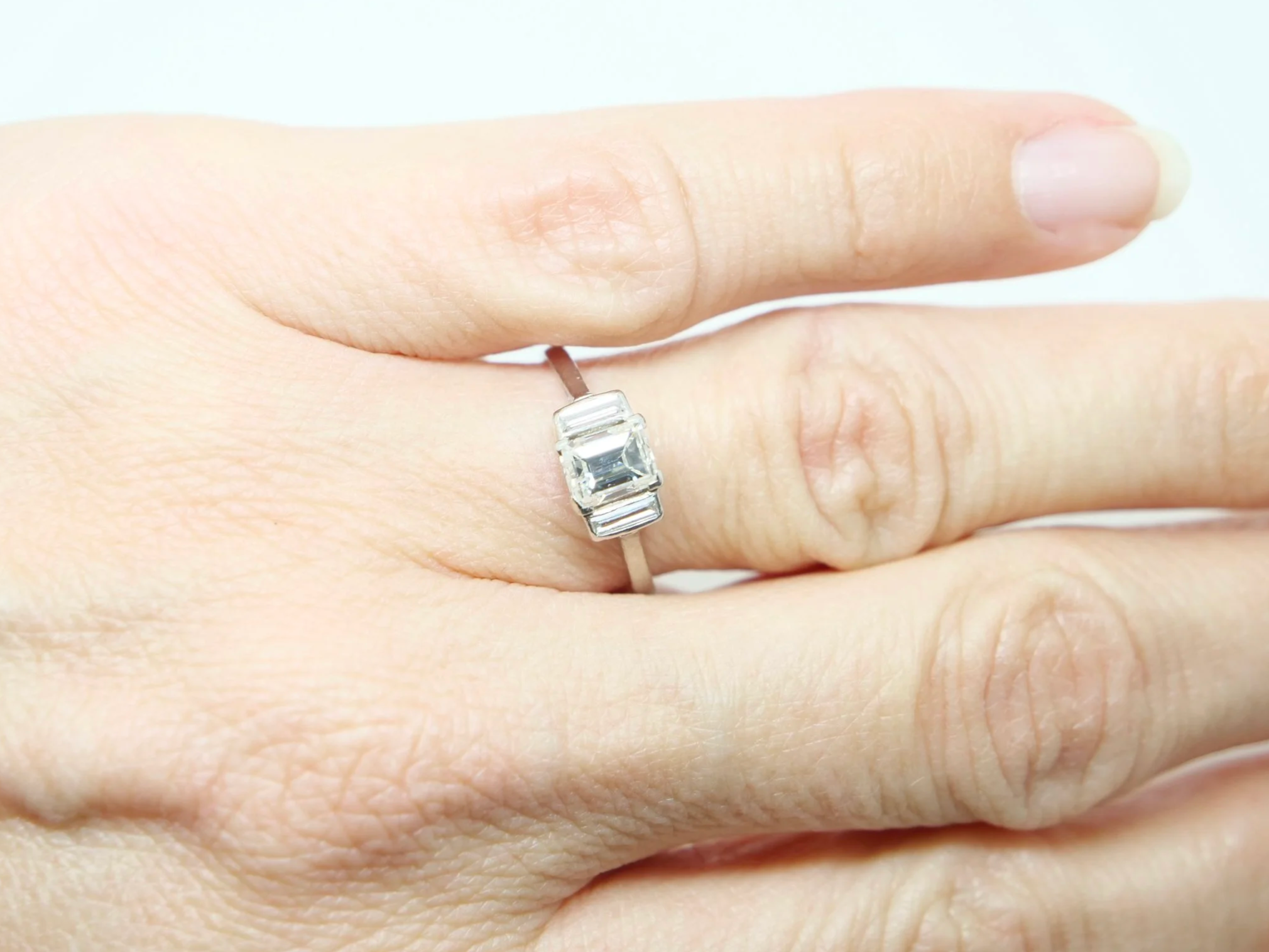 Very unusual vintage platinum diamond ring, set with a lovely baguette cut diamond of approximately 0.95ct. Two further baguette cut diamonds.