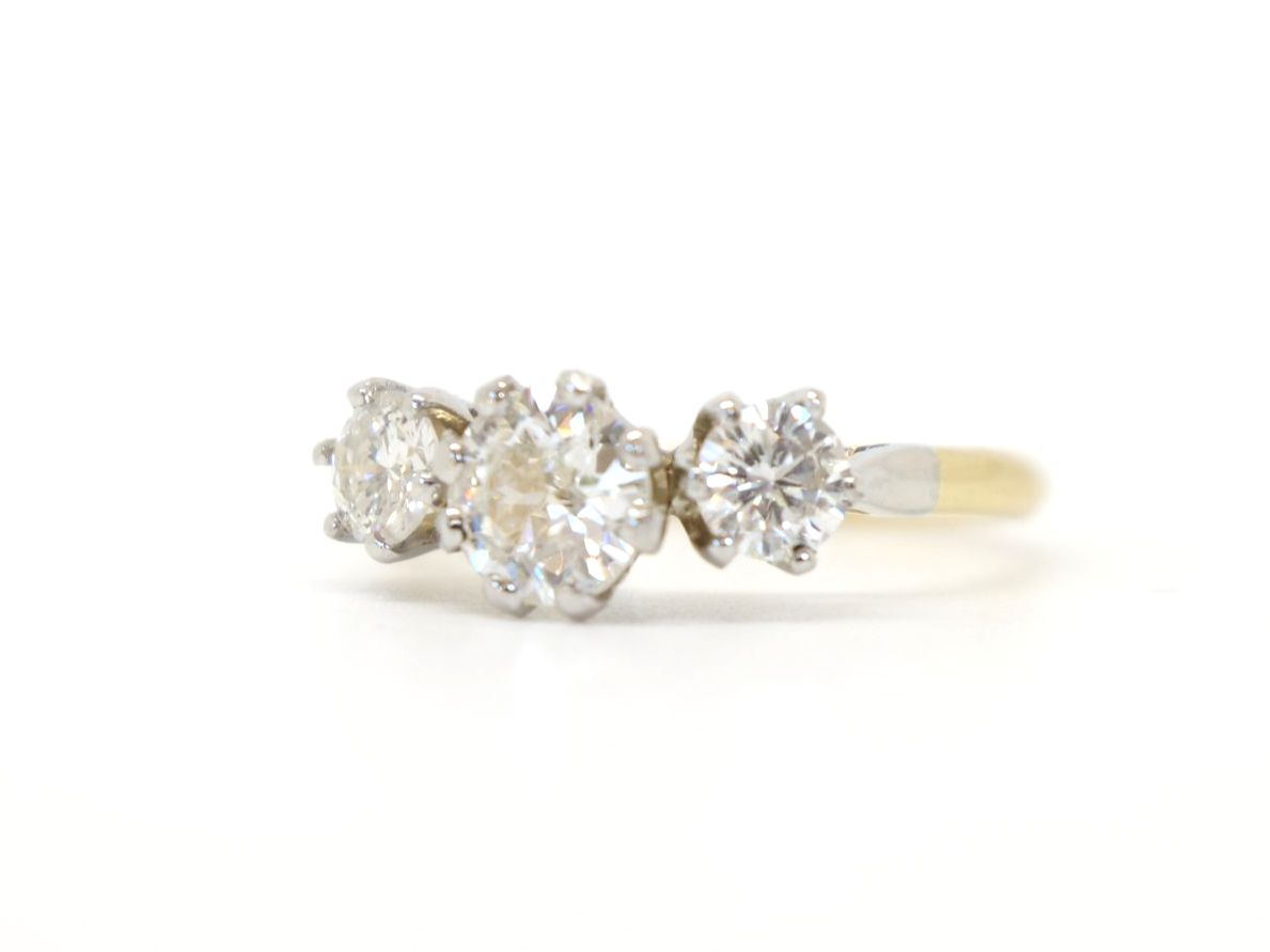 Very bright and sparkly 18ct gold diamond three stone ring, set with a central brilliant cut diamond of approximately 0.68cts. Further diamond to each side, with a total of approximately 1.24ct.