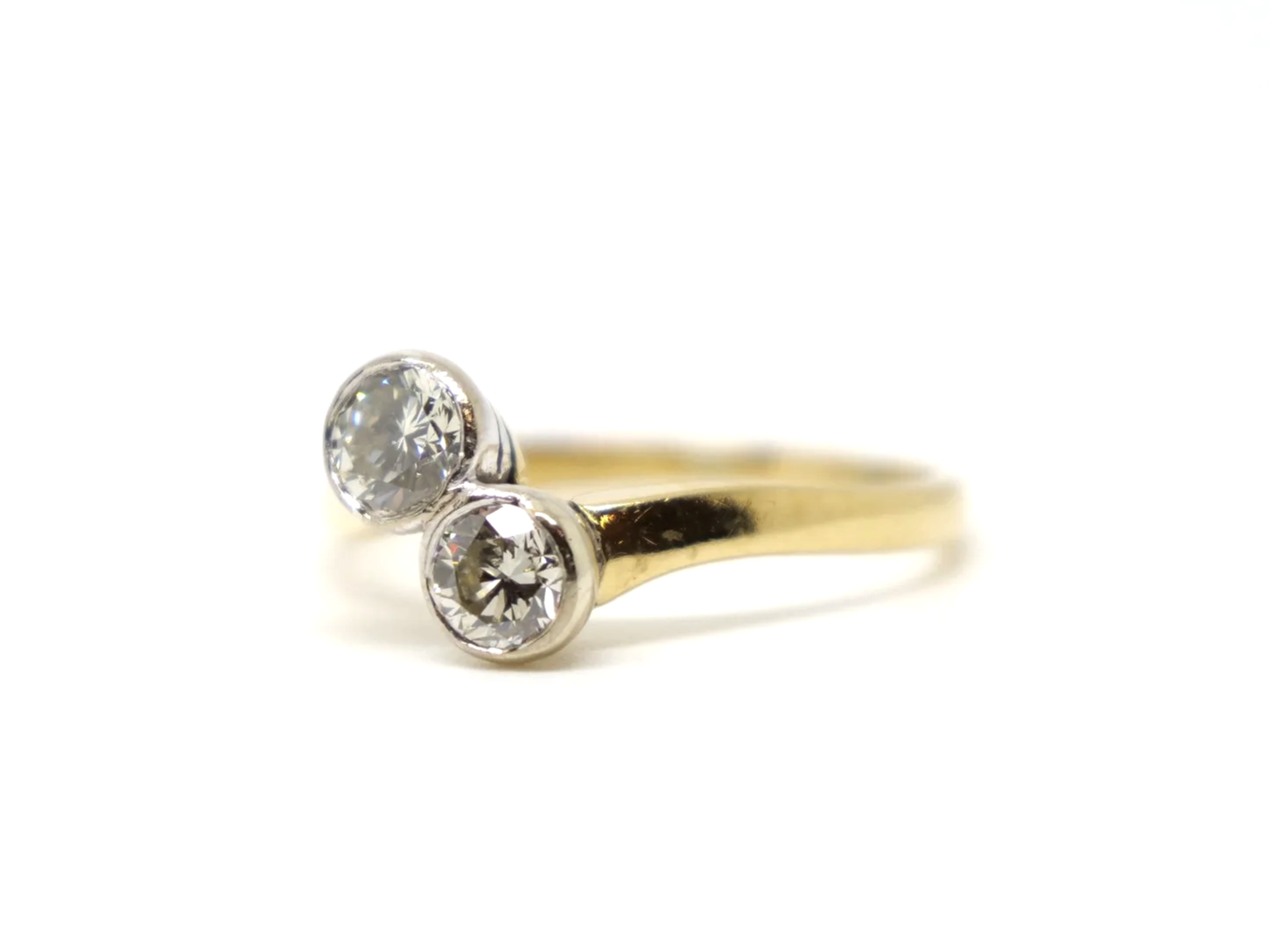 A vintage take on an old Art Deco design, this lovely quality 18ct gold ring is set with two brilliant cut diamonds in this more contemporary toi et moi.
