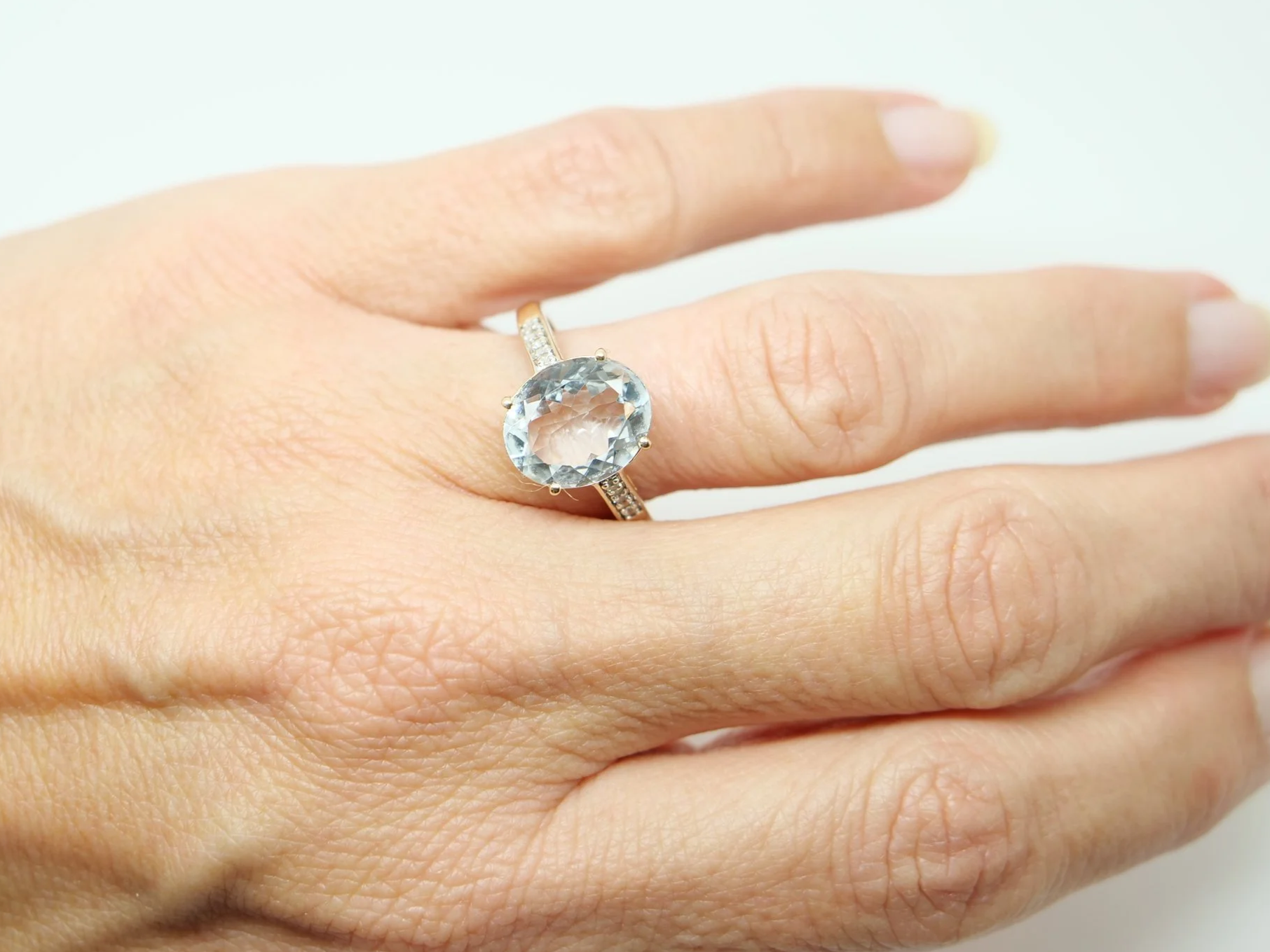 Lovely 10ct gold aquamarine and diamond cocktail ring, set with a large oval cut aquamarine with small diamonds to each shoulder.