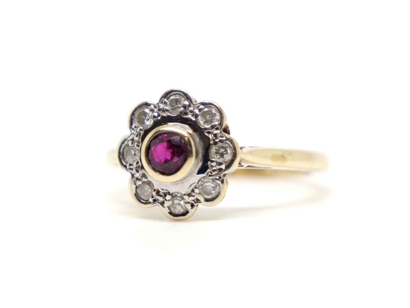 Lovely vintage 9ct ruby and diamond daisy ring, set with a central round cut ruby and surrounded by eight diamonds.