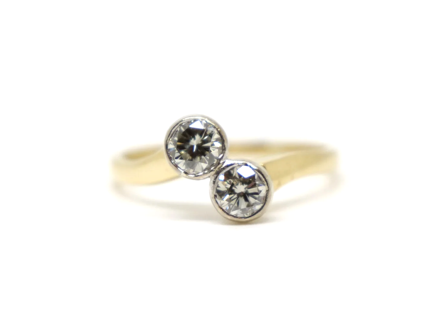 A vintage take on an old Art Deco design, this lovely quality 18ct gold ring is set with two brilliant cut diamonds in this more contemporary toi et moi.