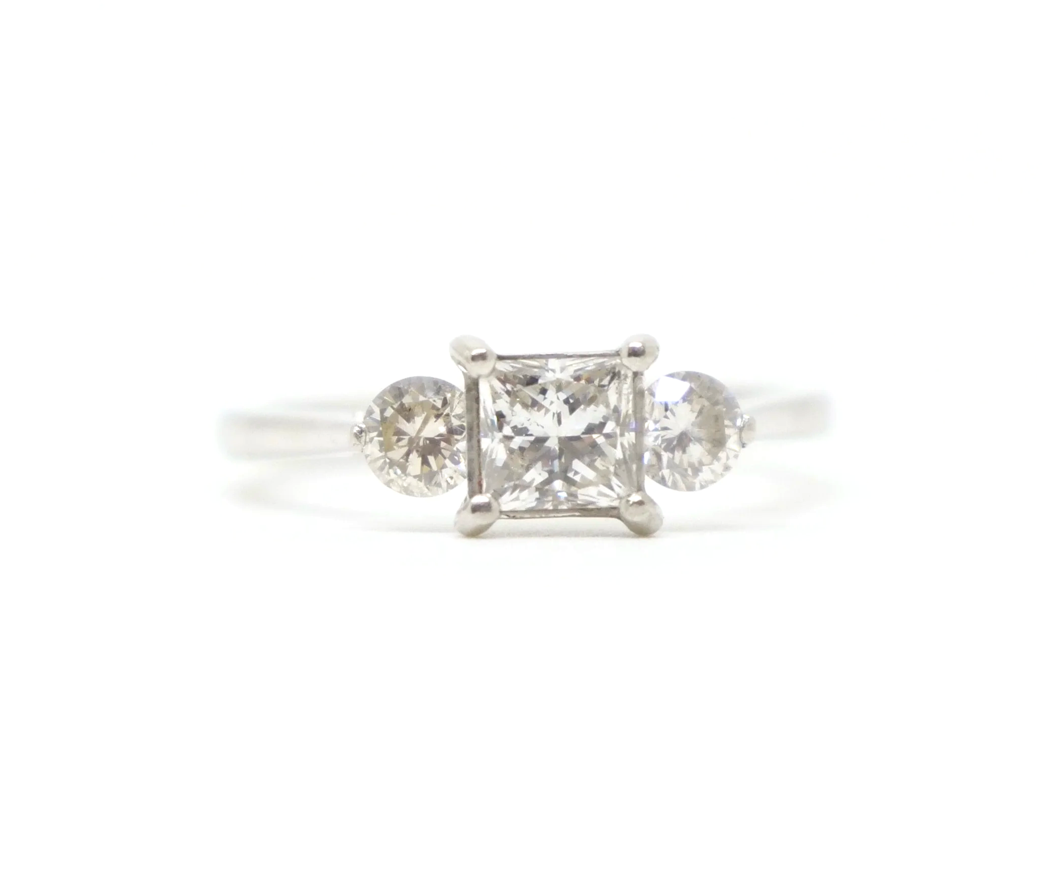Super platinum diamond ring, set with a super princess cut centre diamond, with a brilliant cut diamond to each side.