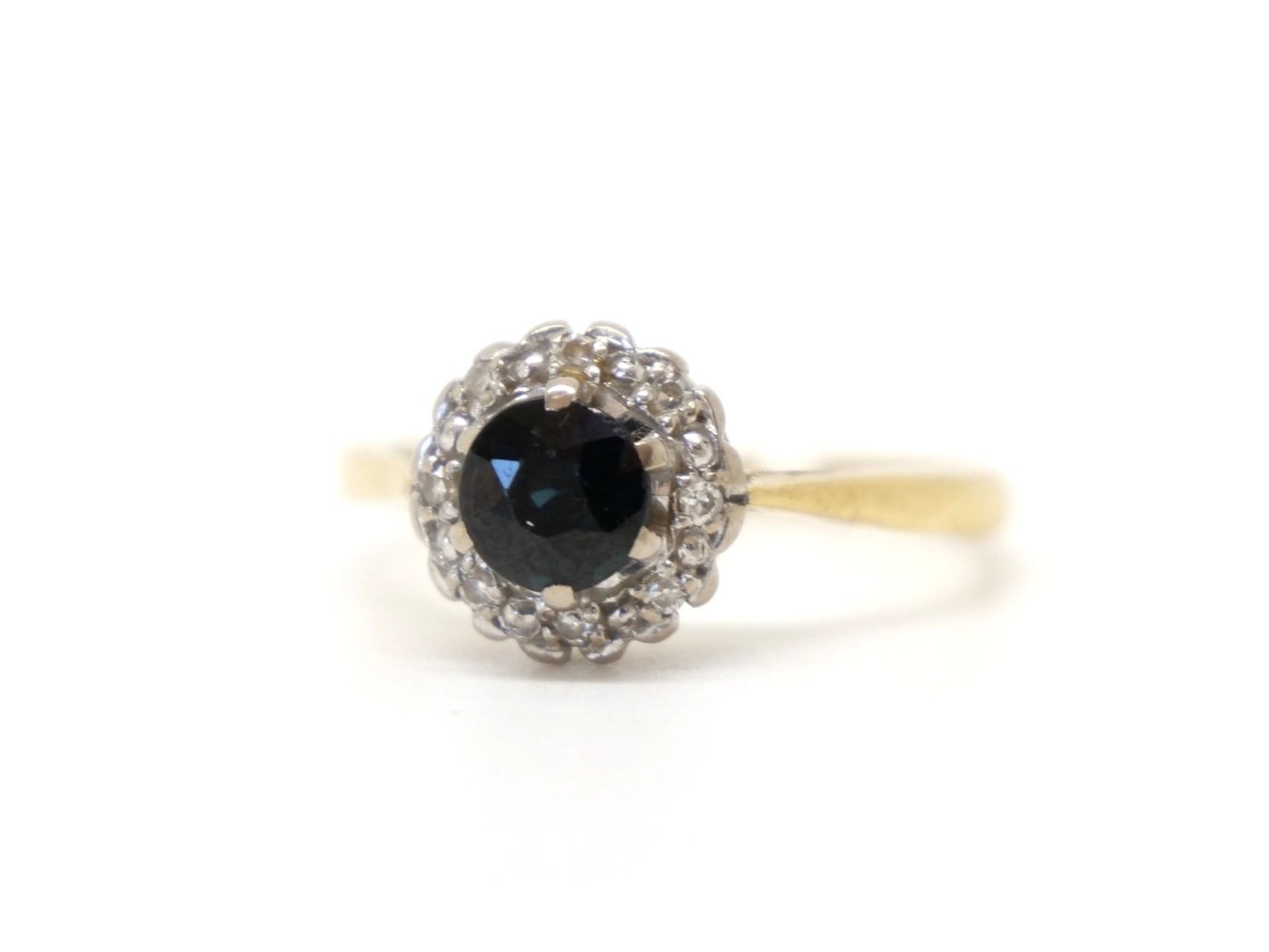 Classic vintage 18ct gold sapphire and diamond ring, set with a central, round cut sapphire of approximately 0.75ct and surrounded by diamonds.