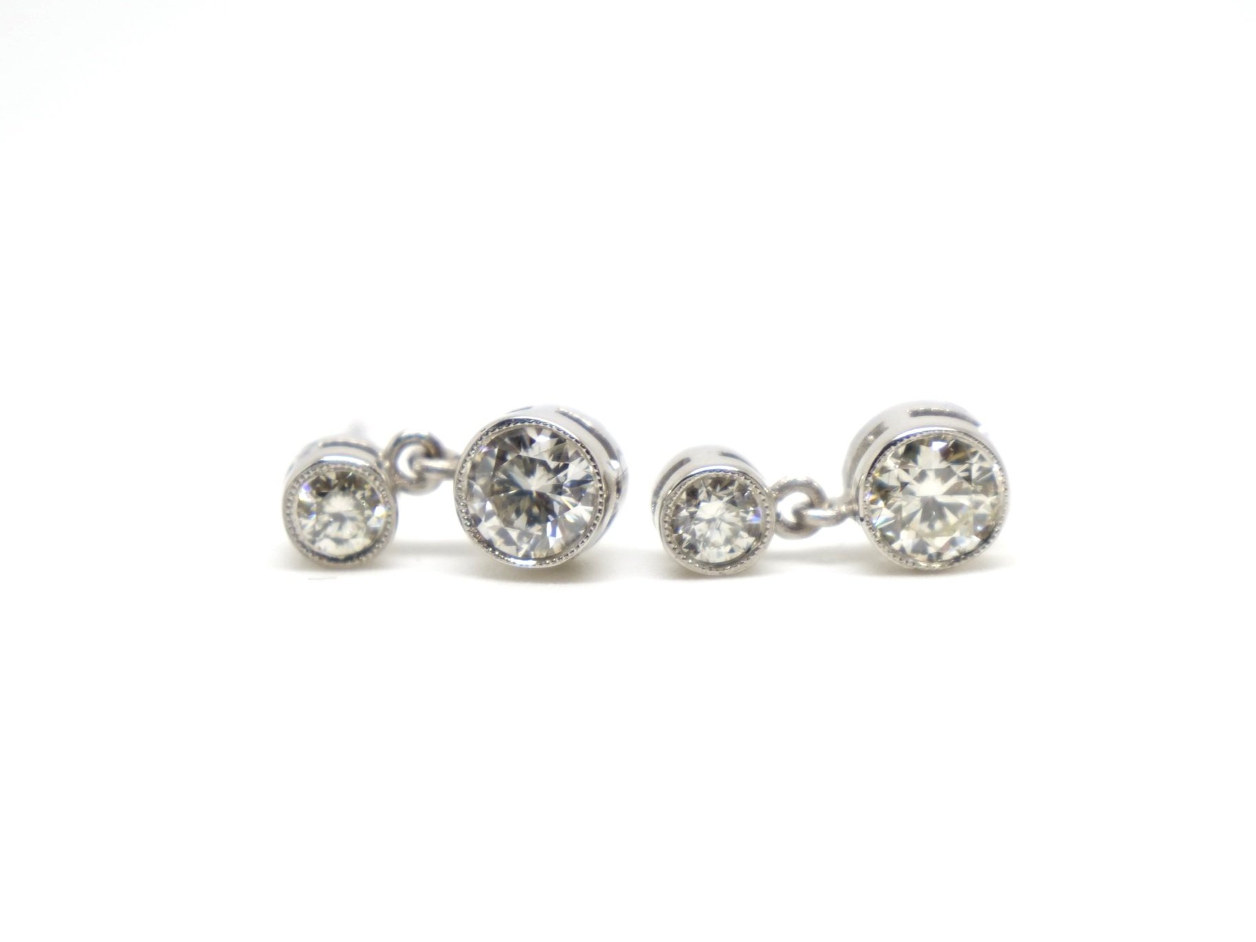 Classic diamond drop stud earrings in a rub over milgrain edged setting. Each earring is set with two brilliant cut diamonds with a total of approximately 0.9cts total.