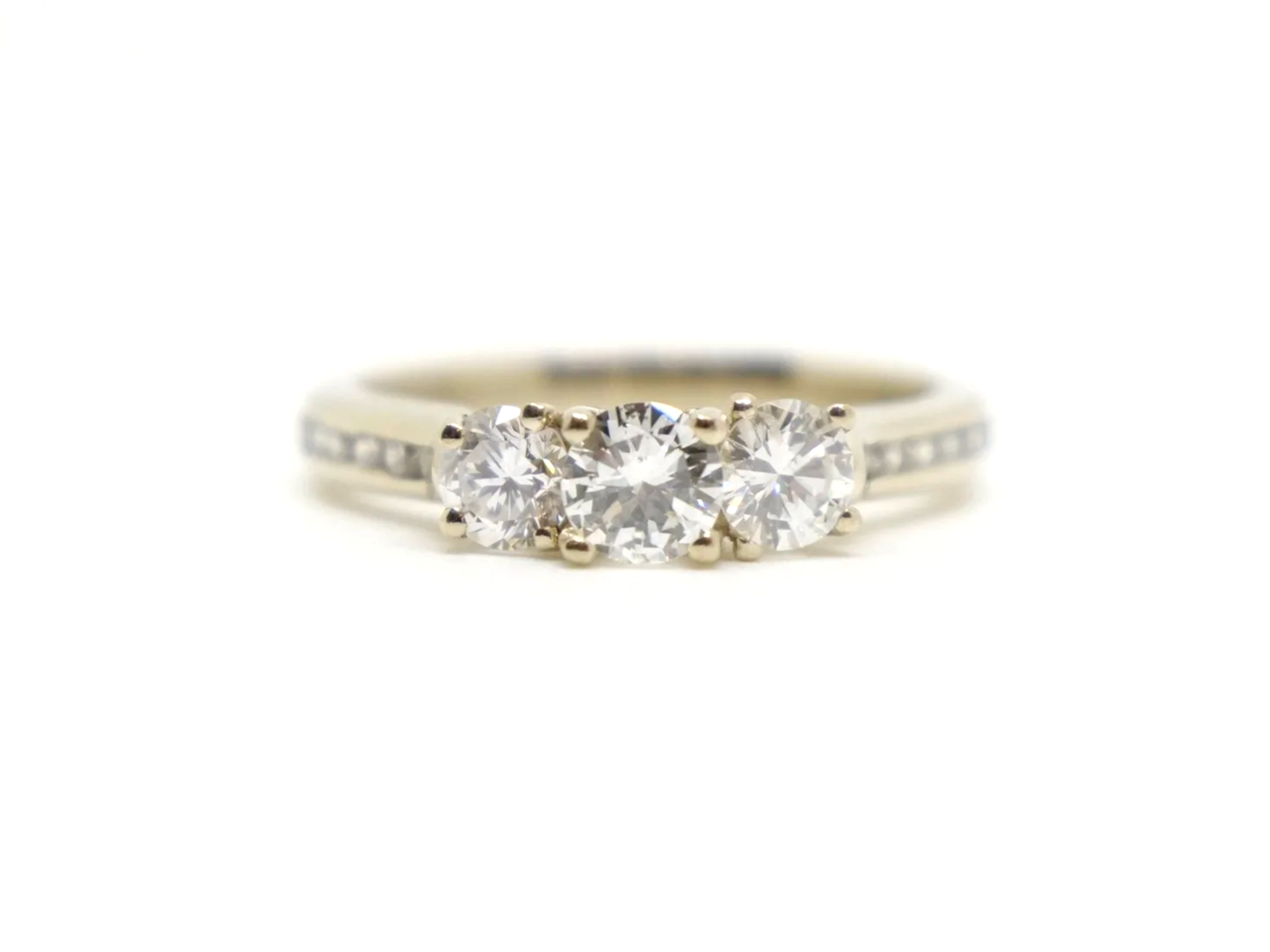 Very pretty 18ct gold diamond three stone ring, set with three brilliant cut diamonds, with further diamonds set into each shoulder. Total diamond weight approximately 1ct.