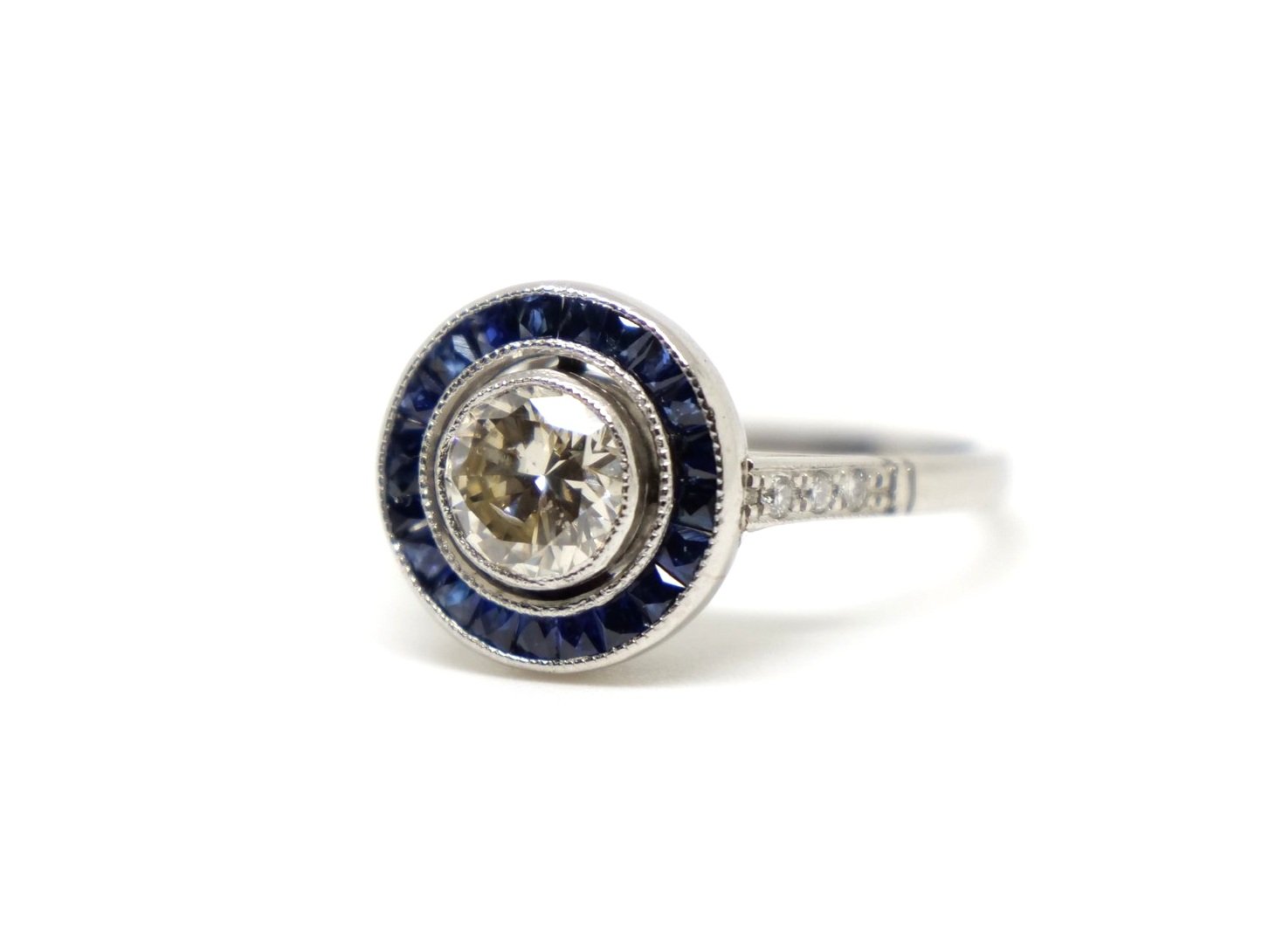 Beautiful platinum sapphire and diamond target ring, set with a central diamond of approximately 0.8cts and surrounded by french cut sapphires.