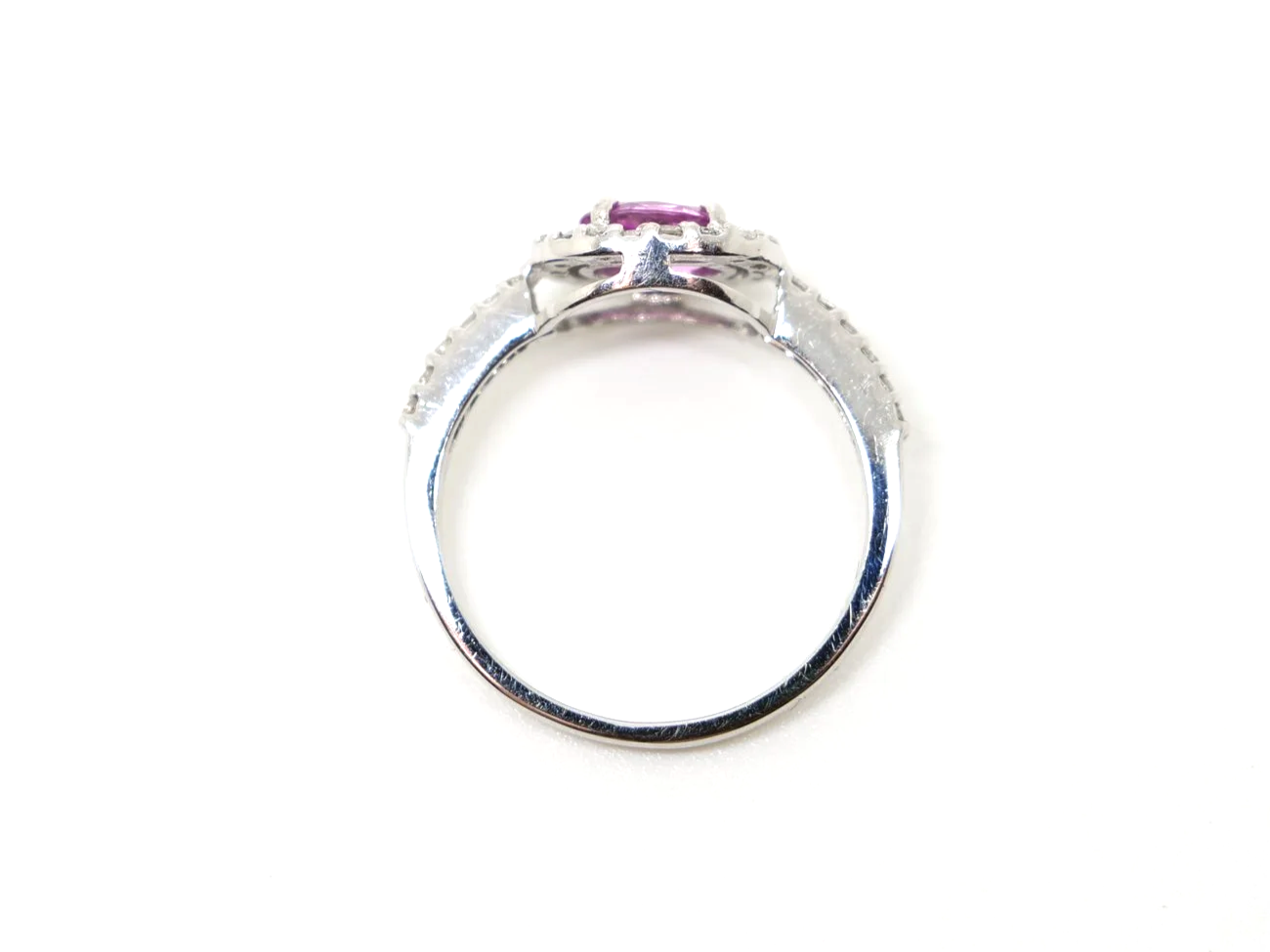 Very sparkly contemporary 18ct gold pink sapphire and diamond ring, set with an oval cut east-west pink sapphire, with a diamond halo. Further diamonds to the shoulders.