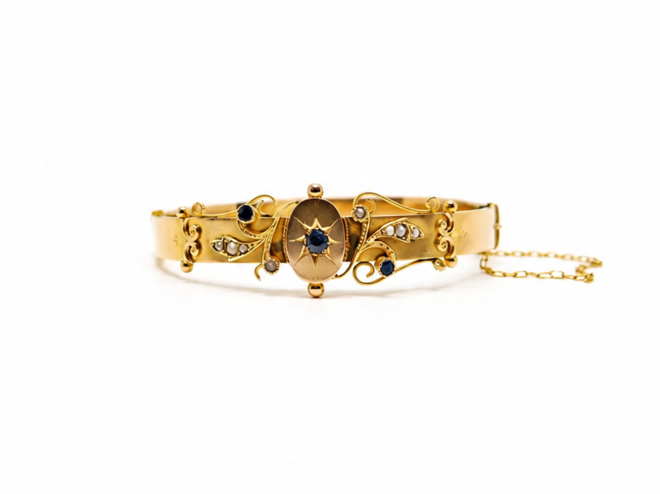 Antique 1907 9ct gold hinged bangle with central star-set sapphire and seed pearl scrollwork