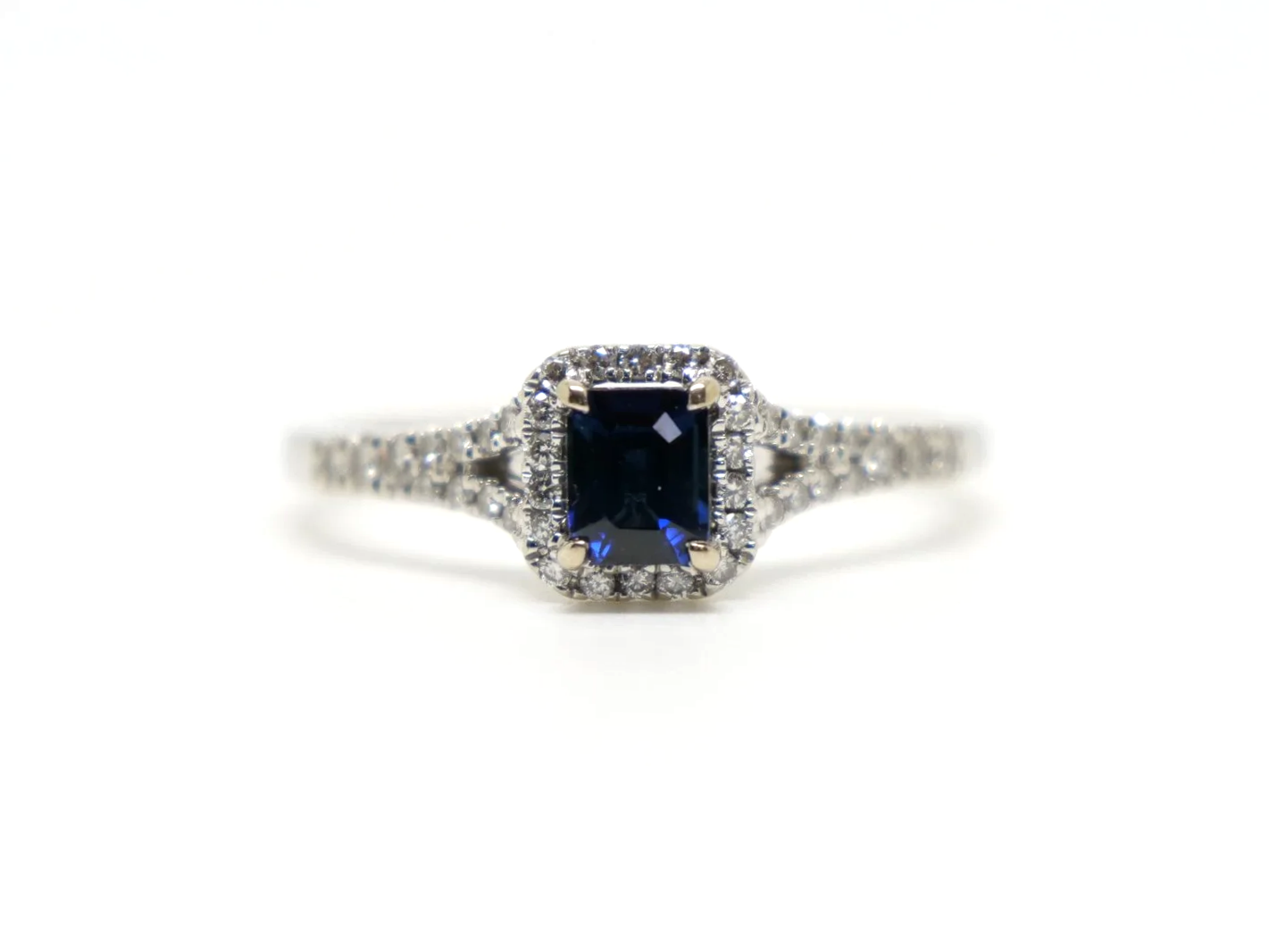 Very pretty contemporary 18ct gold sapphire and diamond ring, set with an emerald cut sapphire with diamond halo.