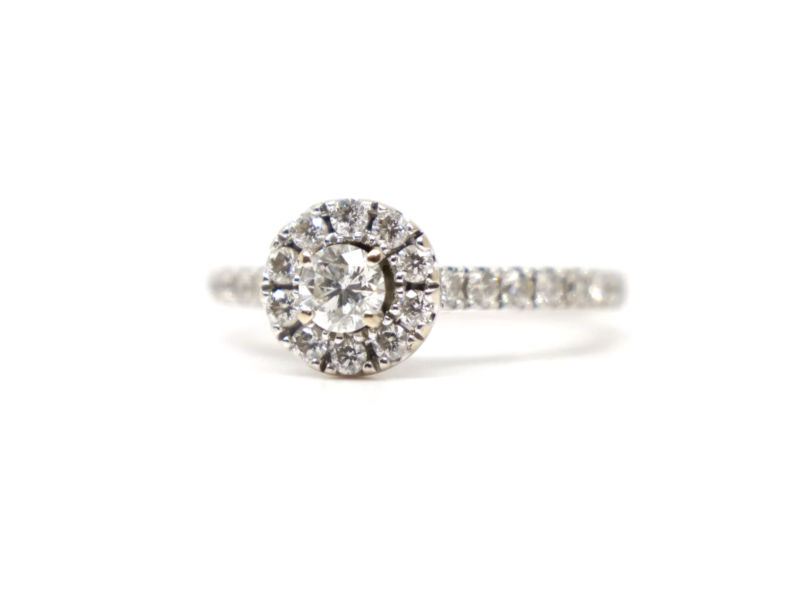 14ct white gold diamond halo ring set with a round brilliant cut diamond at the centre surrounded by a pavé-set halo of smaller diamonds