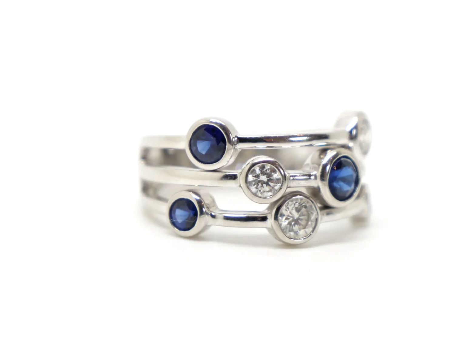 Beautiful platinum sapphire and diamond ring, often called a bubble ring and designed in the style of Boodles Raindance collection. Set with four sapphires and three diamonds.