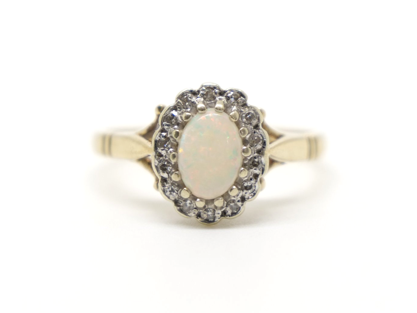 Very pretty vintage 9ct gold opal and diamond cluster ring, set with an oval opal and surrounded by small diamonds.