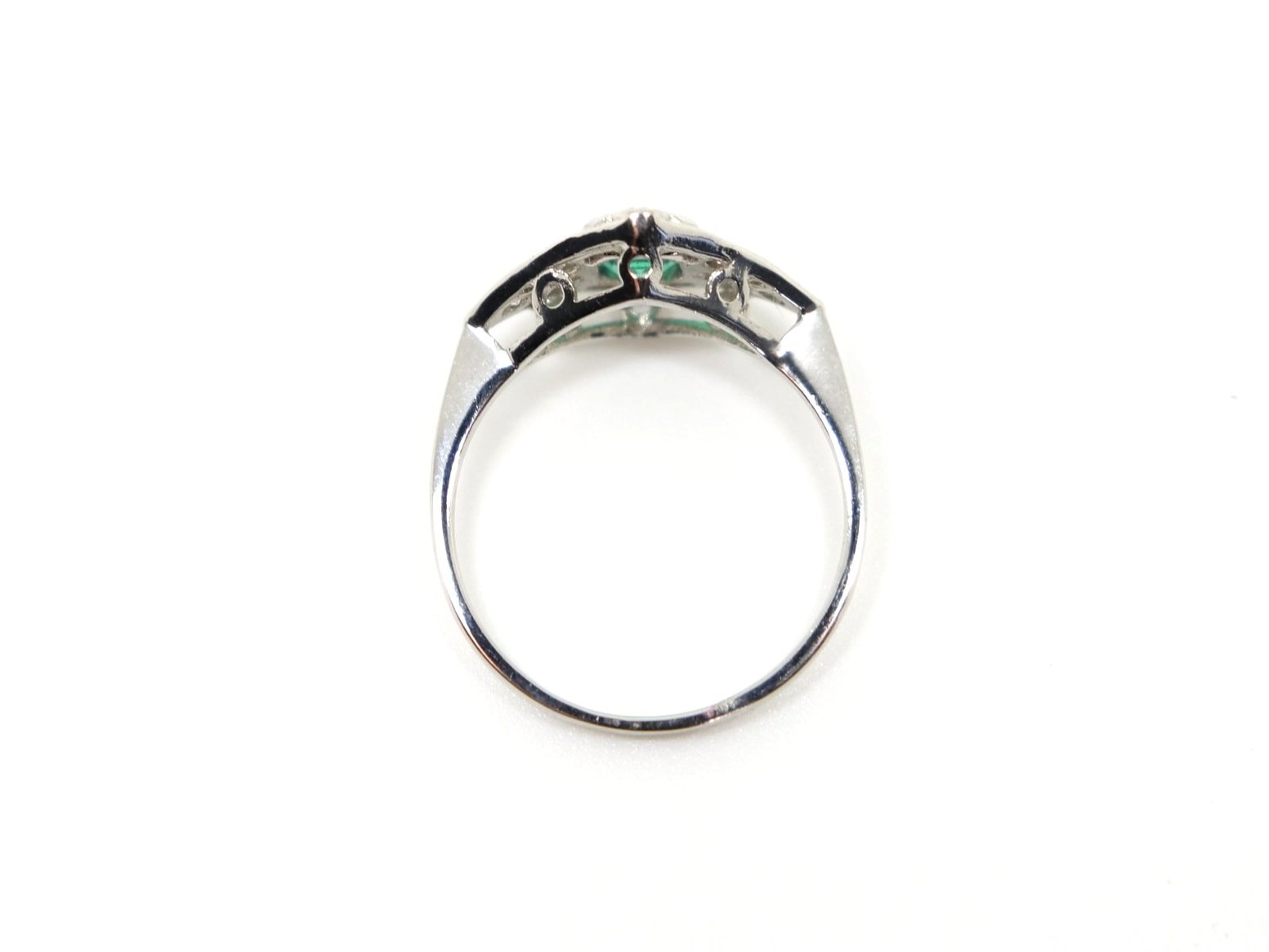 Very pretty Art Deco style platinum ring, set with an emerald cut emerald and set with diamonds in this lovely geometric design.