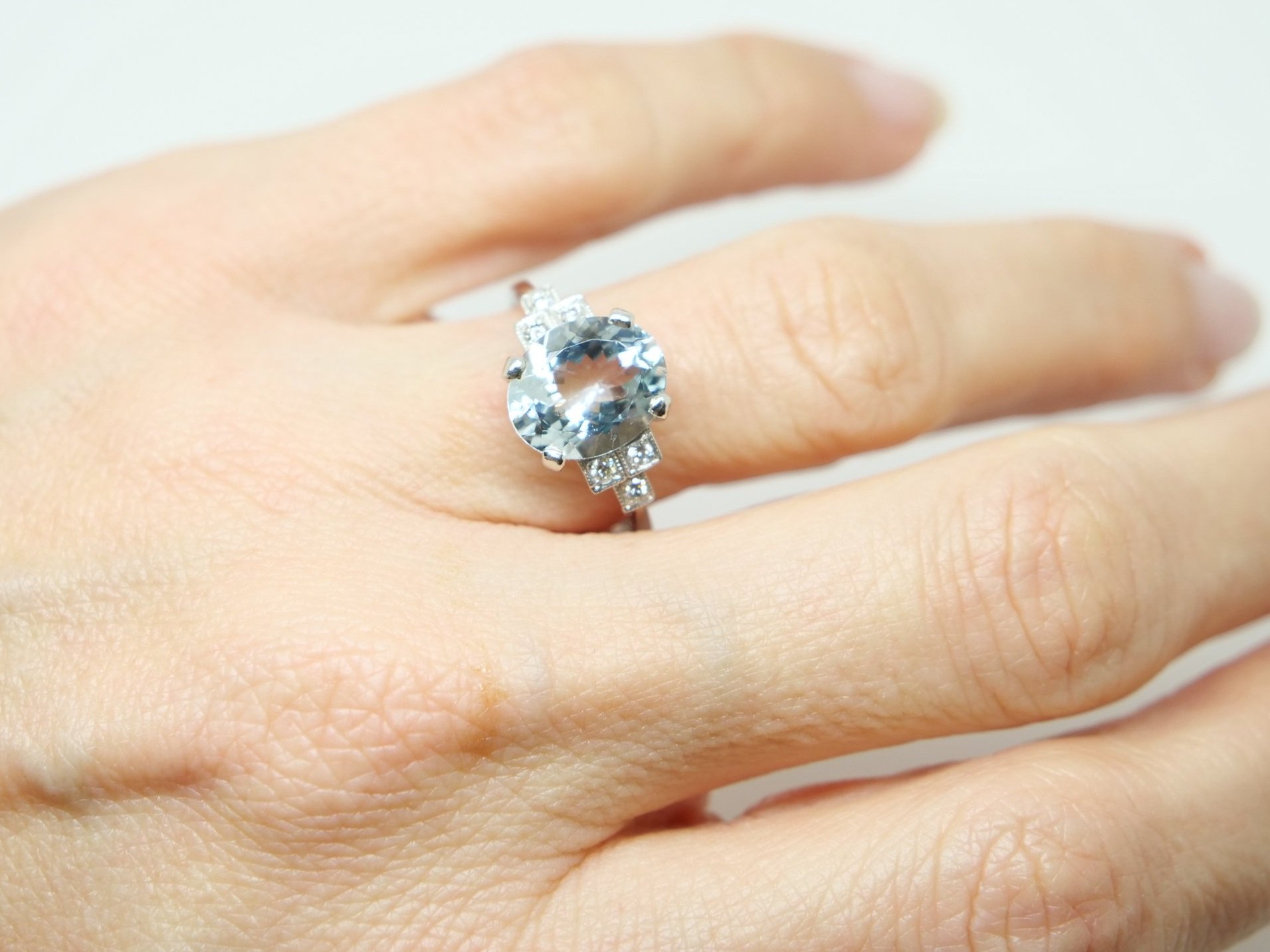 Super platinum Art Deco style aquamarine and diamond ring, set with a central oval cut aquamarine of approximately 3cts, with diamonds set in a step design into each shoulder.