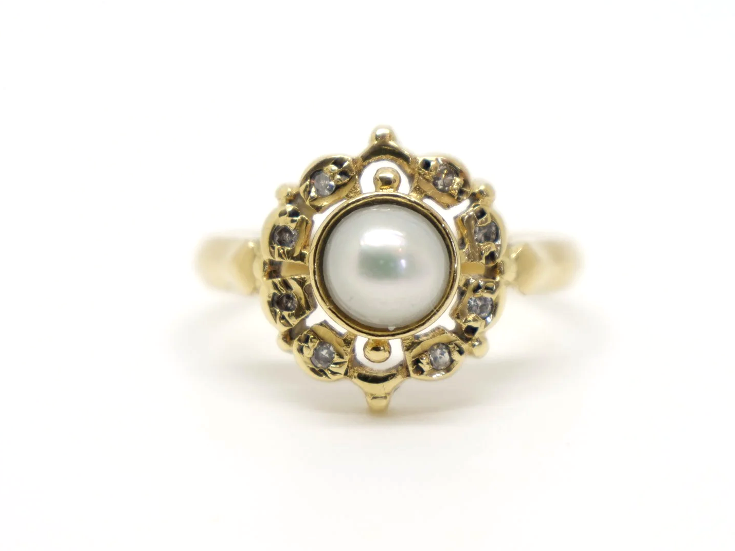 Very pretty 18ct gold pearl and diamond ring in a lovely north-south shaped design. Set with a central pearl and surrounded by small diamonds.