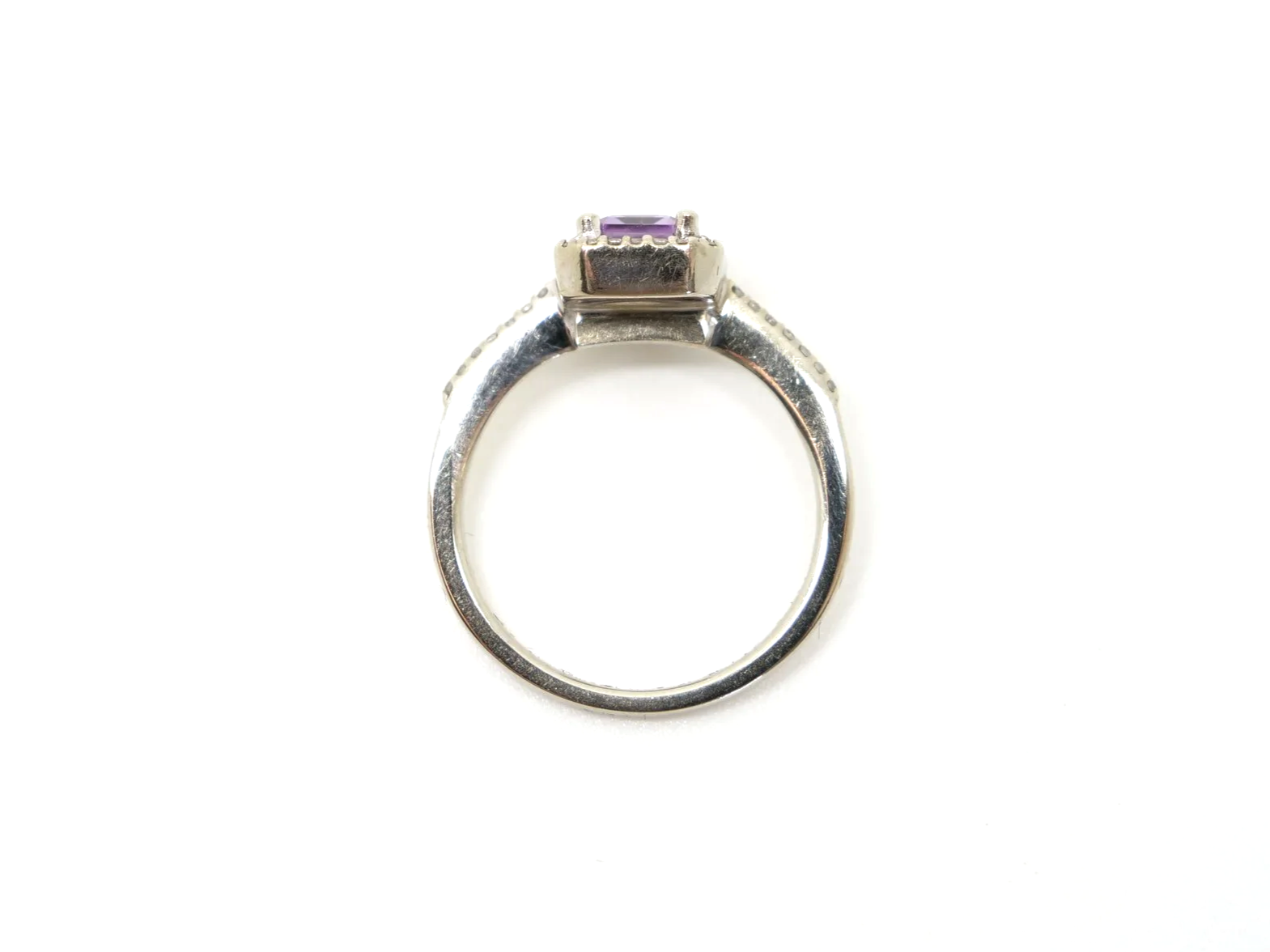 Contemporary design 9ct gold amethyst and diamond ring, set with an emerald cut amethyst and surrounded by diamonds. Further diamonds to each shoulder.