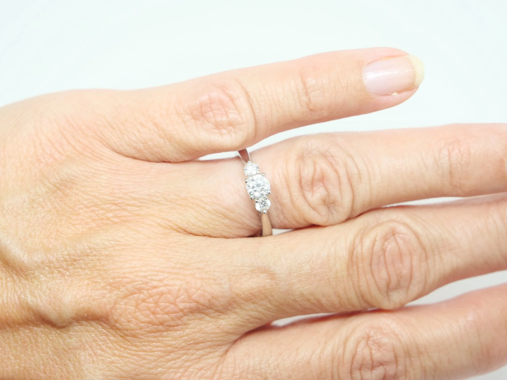 Platinum three stone diamond ring, central diamond flanked by two round diamonds