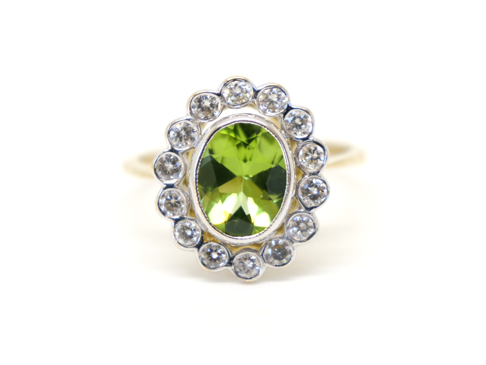 Superb vintage 18ct gold peridot and diamond ring, set with a 1.6ct oval cut peridot and surrounded by approximately 0.55cts of brilliant cut diamonds.