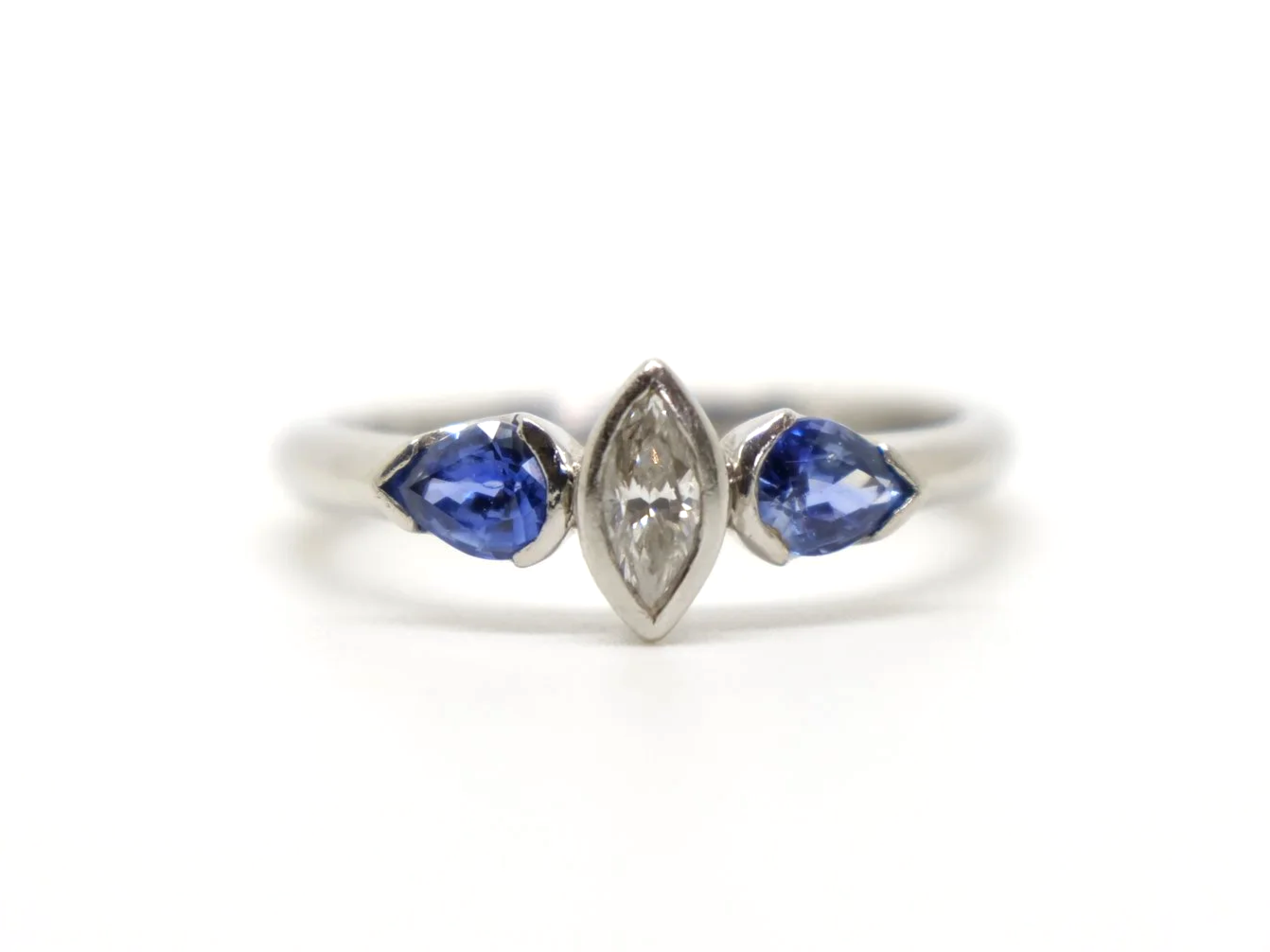 Beautiful platinum diamond and sapphire three stone ring, set with a marquise cut diamond and two pear cut sapphires.