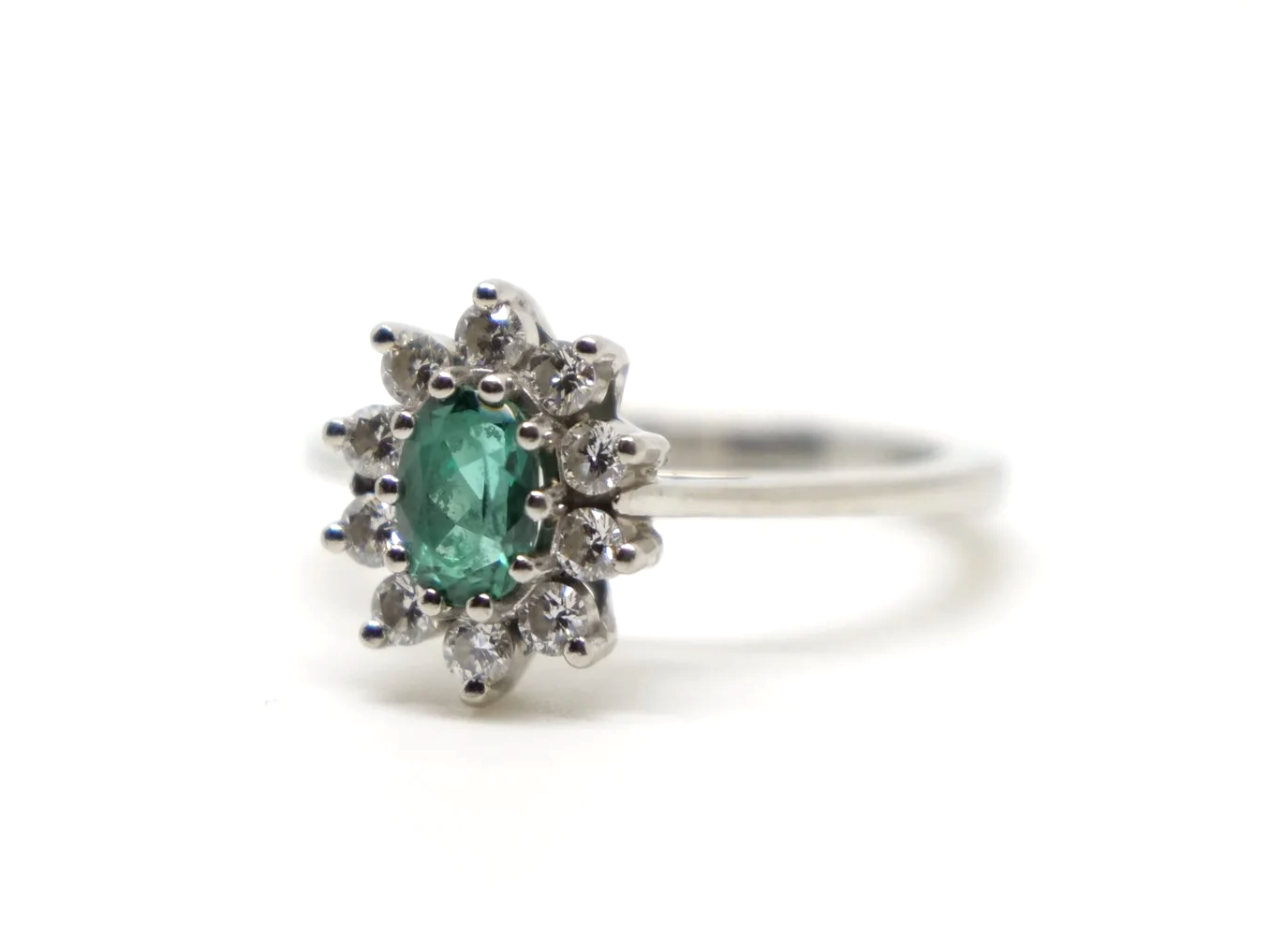Unusual platinum green tourmaline and diamond cluster ring, set with an oval cut green tourmaline and surrounded by lovely sparkly diamonds.