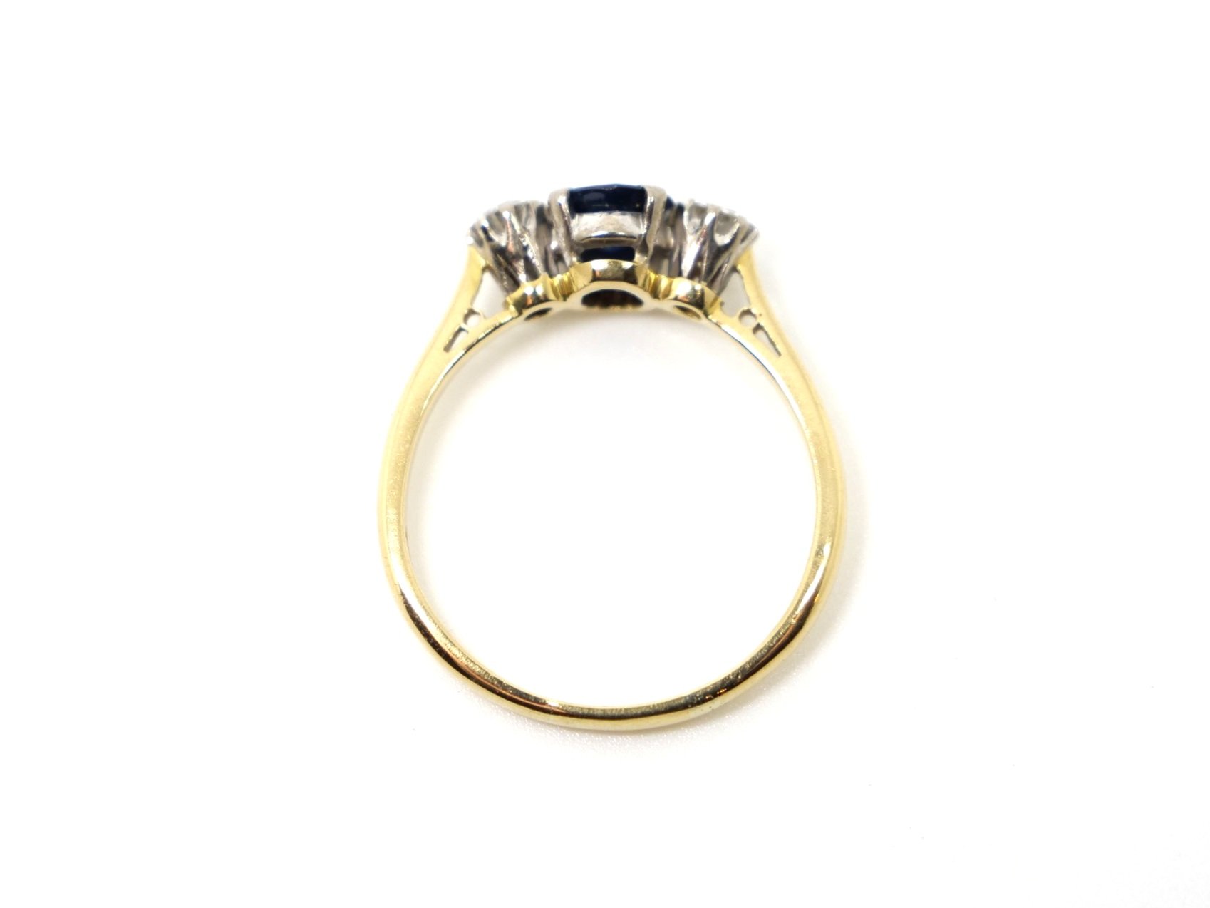 Lovely vintage 18ct gold trilogy ring set with a central round cut sapphire, with a brilliant cut diamond to each shoulder.