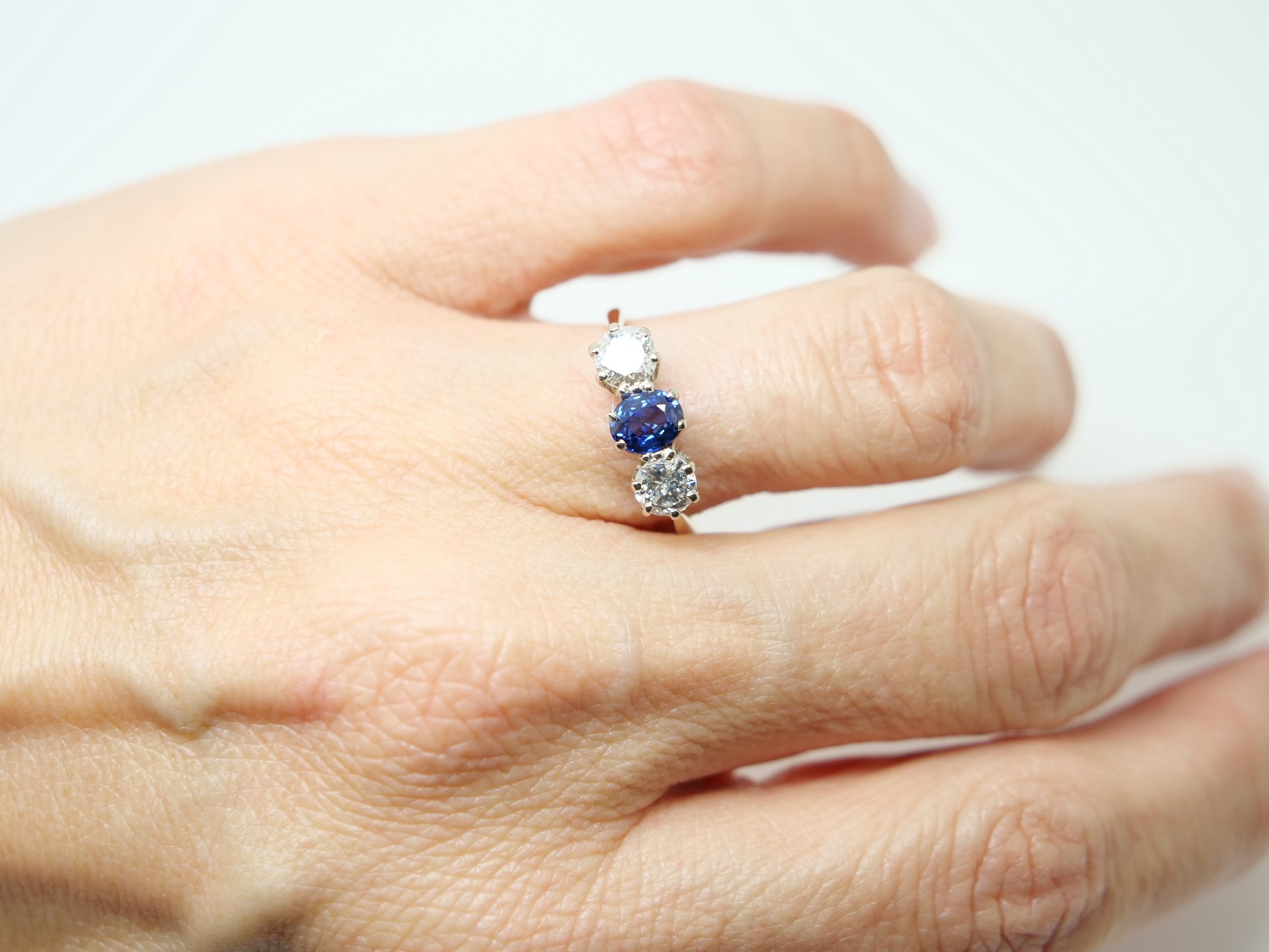 Super vintage 18ct gold and platinum sapphire and diamond trilogy ring, set with a central oval cut sapphire, with a large brilliant cut diamond to each side.