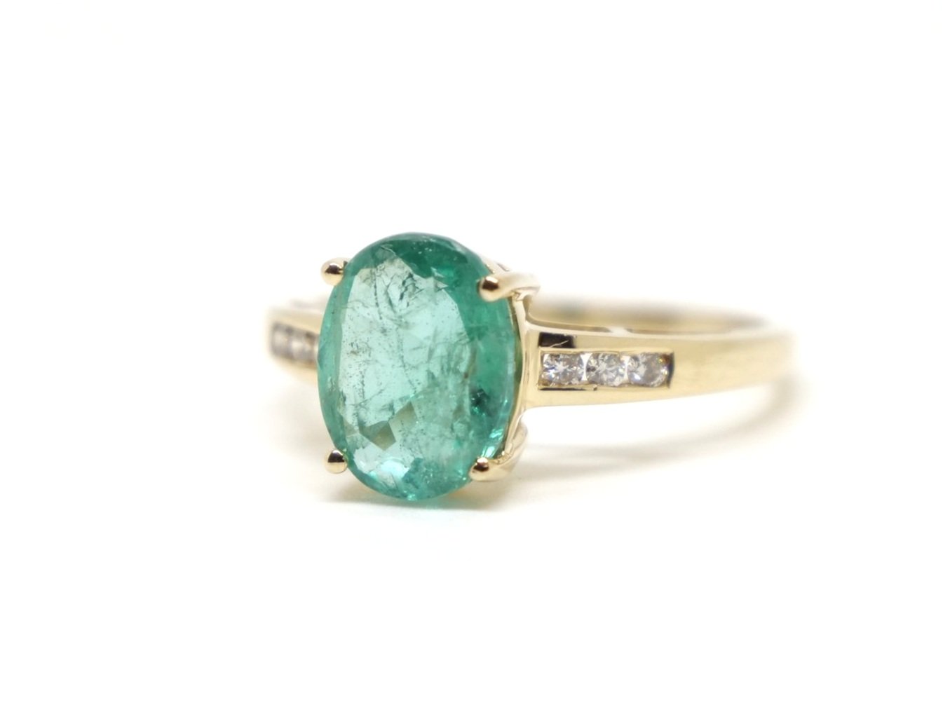 Preloved 14ct gold emerald and diamond ring, set with a large oval cut emerald of approximately 1.75cts, with three diamonds set to each shoulder.