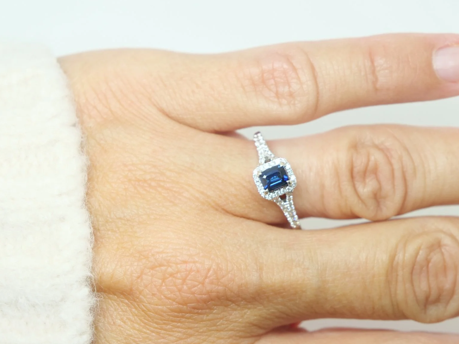 Very pretty contemporary 18ct gold sapphire and diamond ring, set with an emerald cut sapphire with diamond halo.