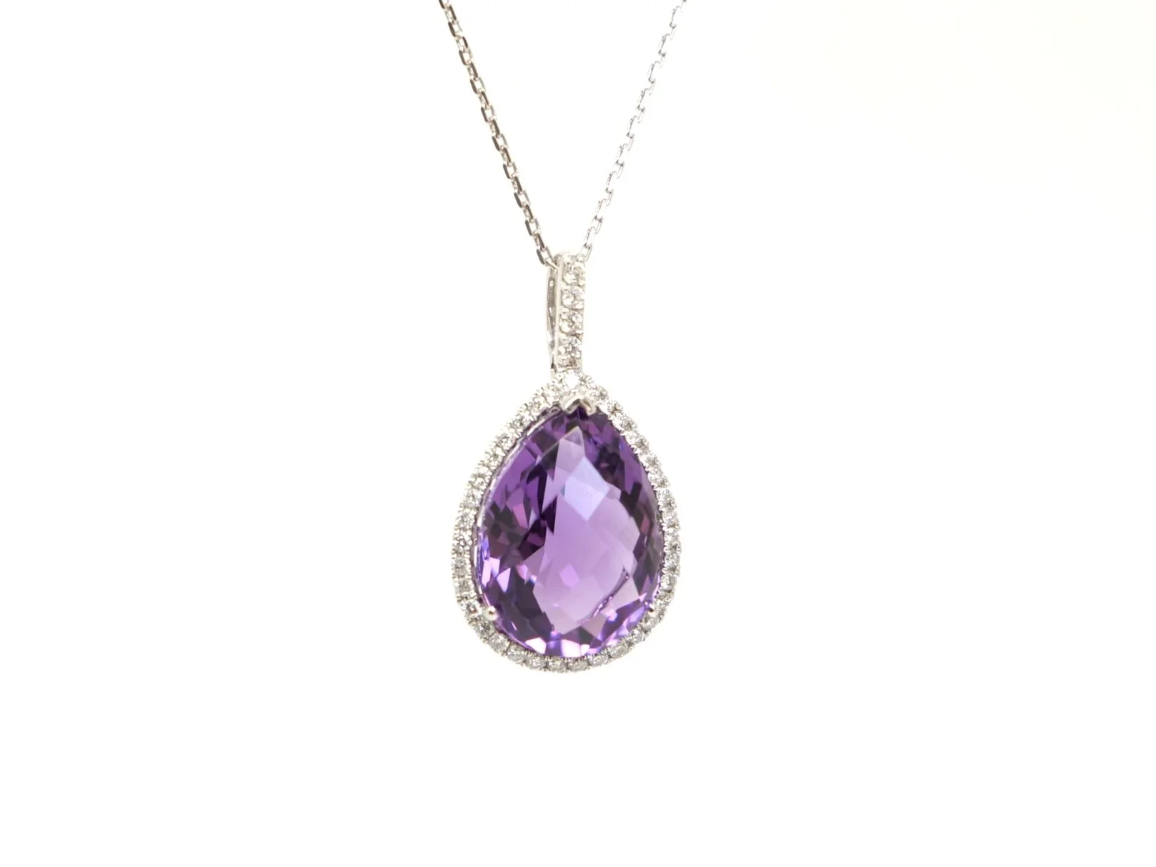 Very pretty 14ct gold amethyst and diamond pendant, set with a large pear cut amethyst and surrounded by diamonds. Further diamonds to bale. With 9ct white gold chain.