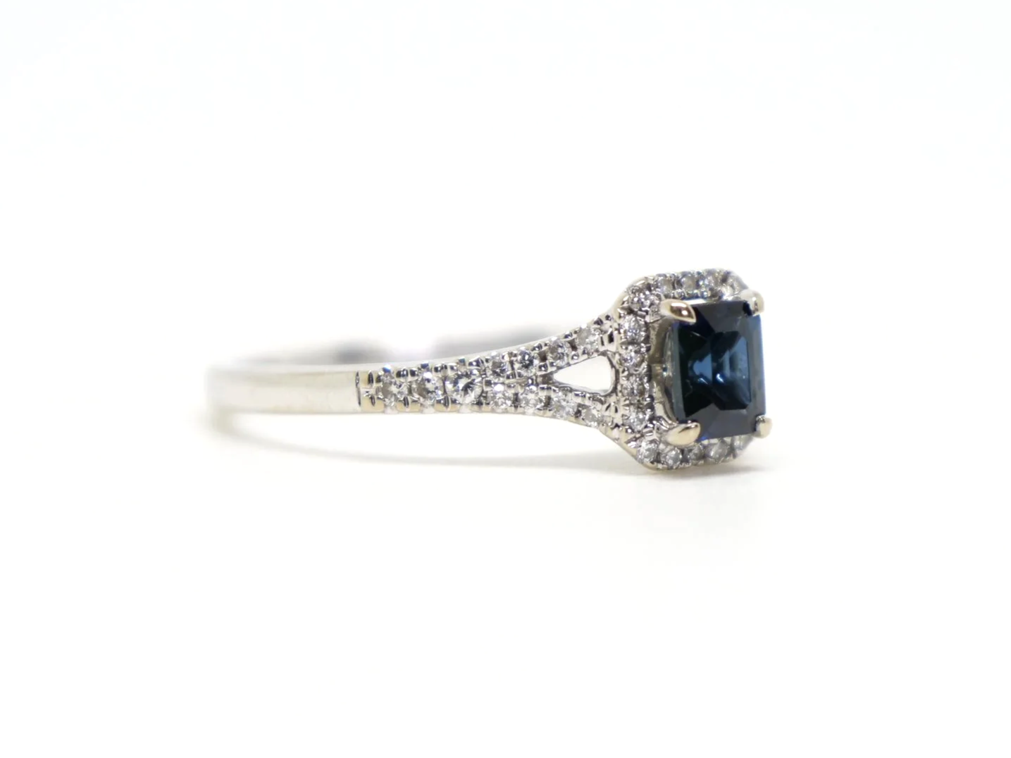 Very pretty contemporary 18ct gold sapphire and diamond ring, set with an emerald cut sapphire with diamond halo.