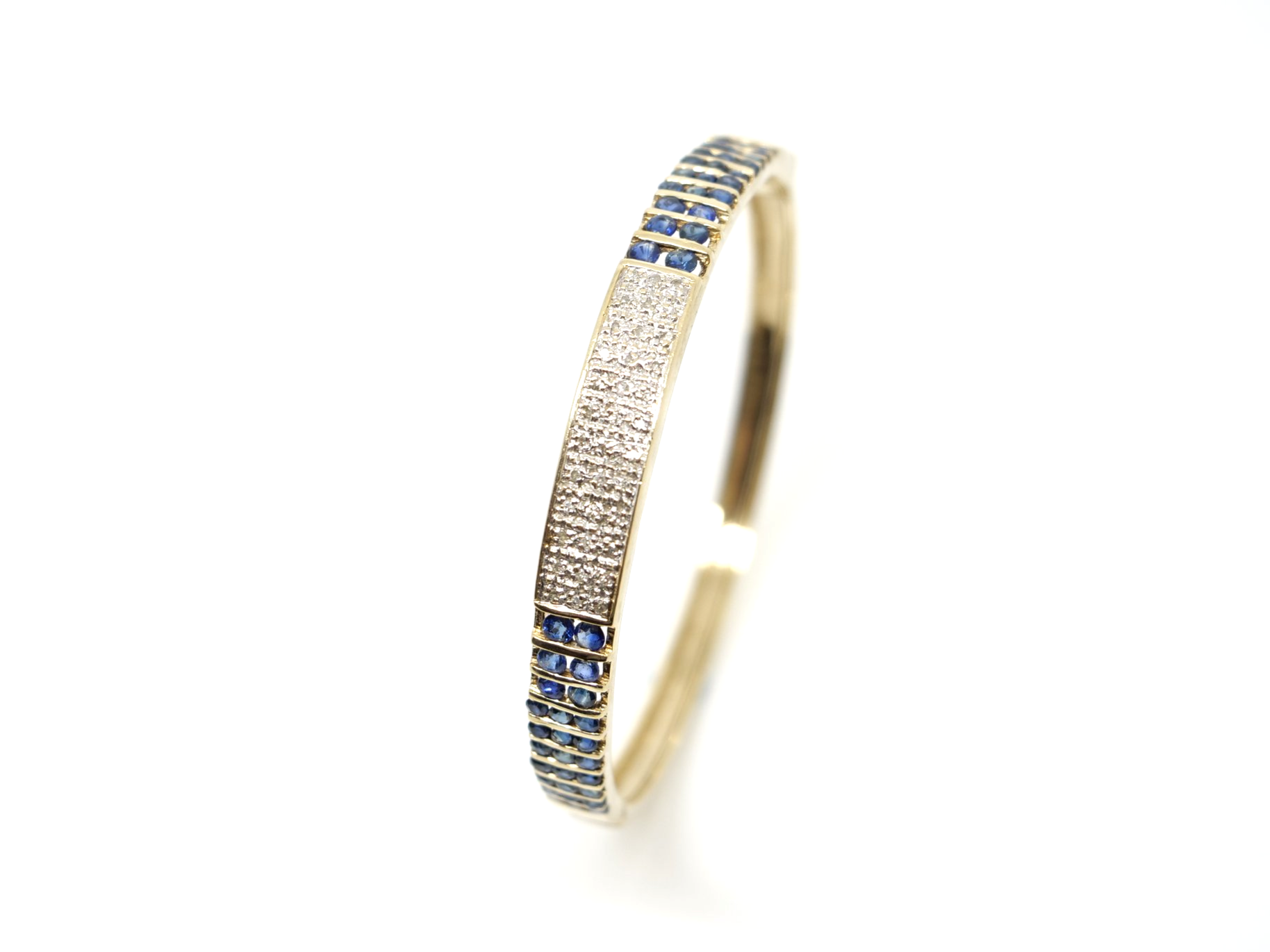 Unusual vintage 9ct gold sapphire and diamond bangle, set with a pave design central panel set with diamonds, with channel set sapphires to each side.