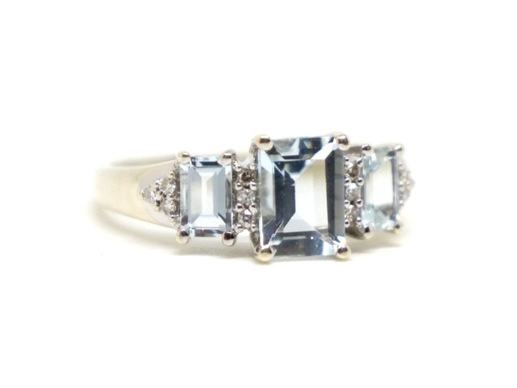 Pretty aquamarine trilogy ring, set with three emerald cut aquamarines, with small diamonds both in between and to each shoulder. Set in 9ct white gold.