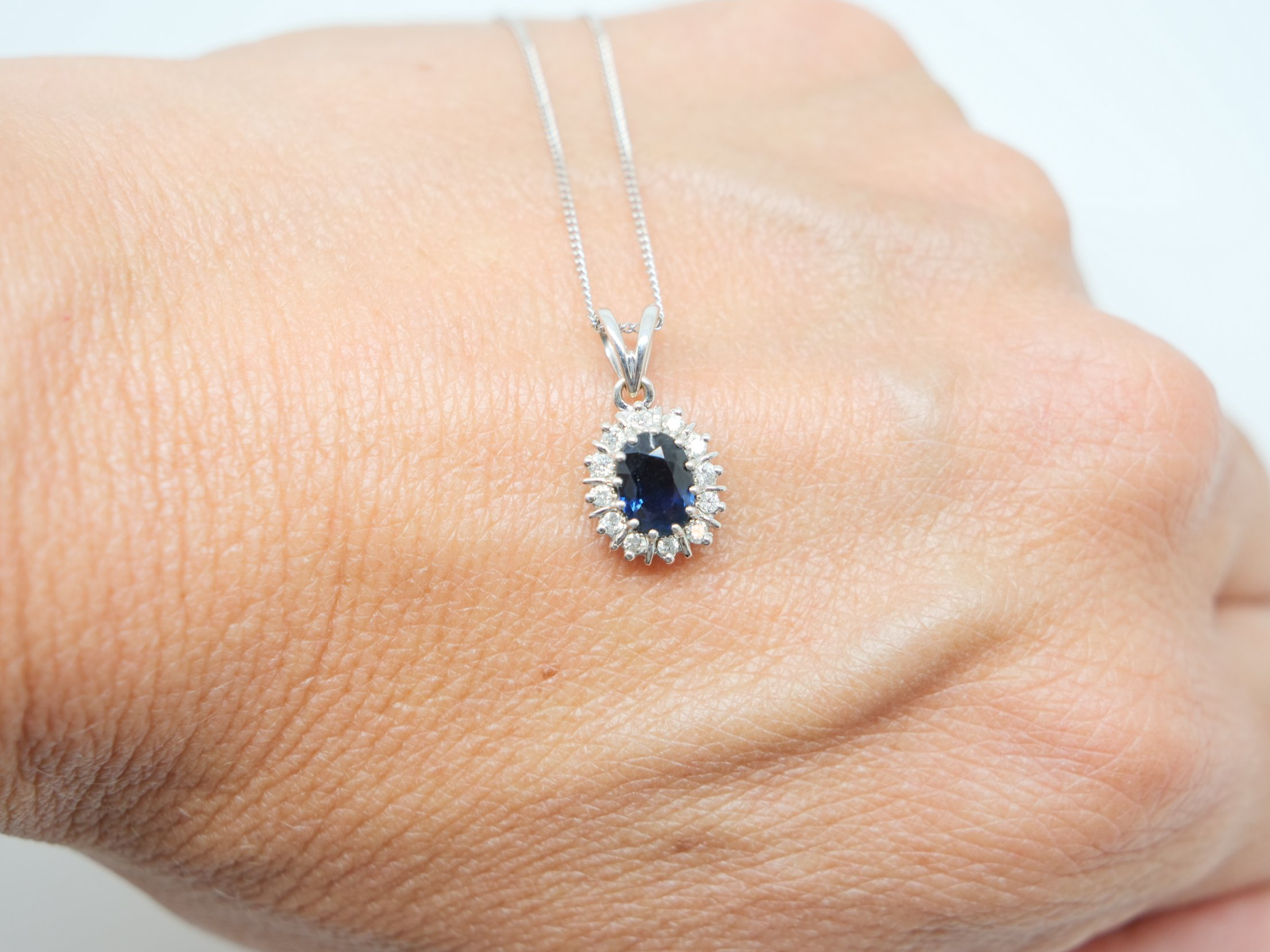 Lovely 18ct gold preloved sapphire and diamond pendant and chain, set with an approximately 1ct sapphire and surrounded by diamonds.
