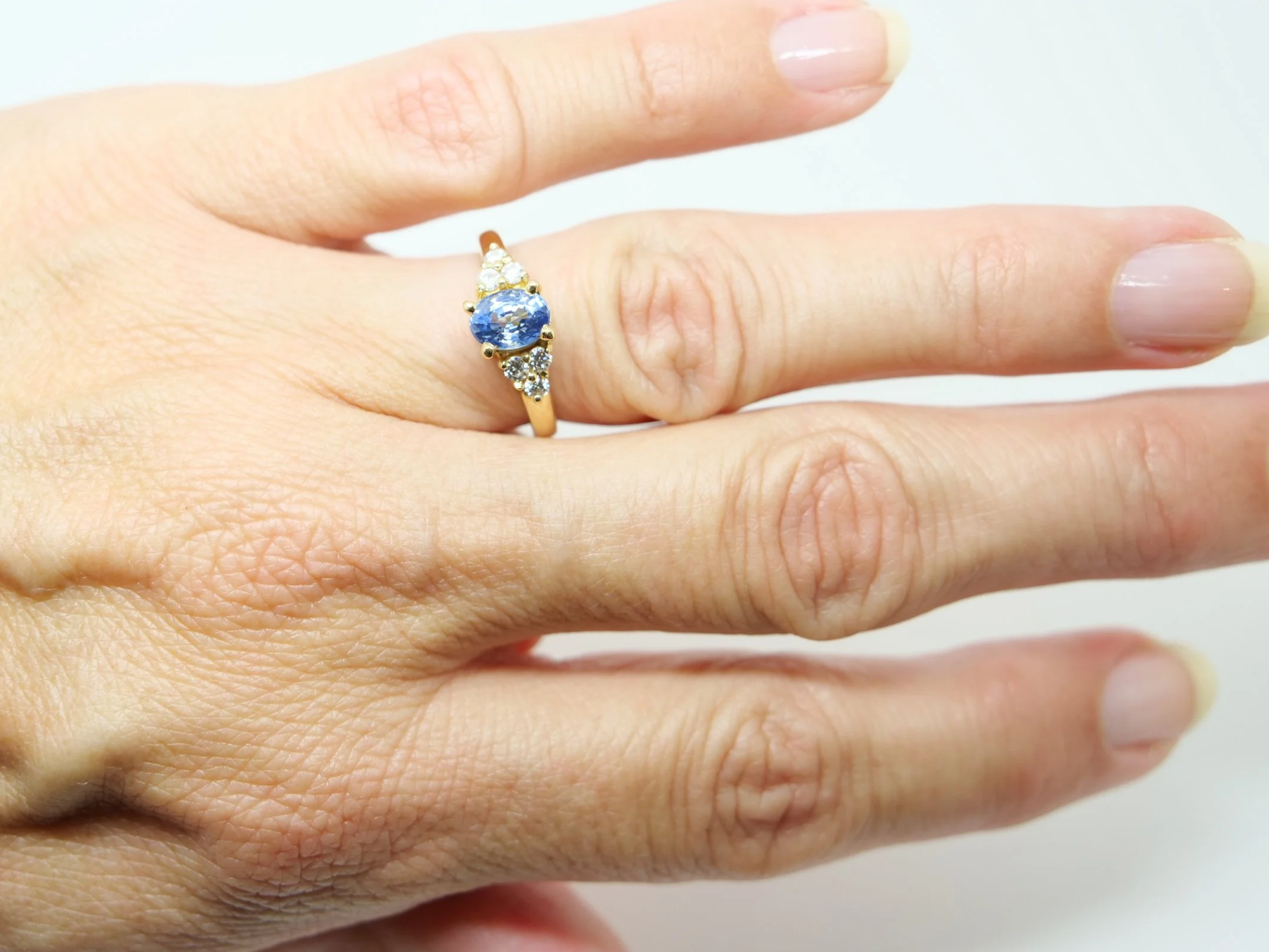 18ct gold ring with central oval sapphire and diamond shoulders
