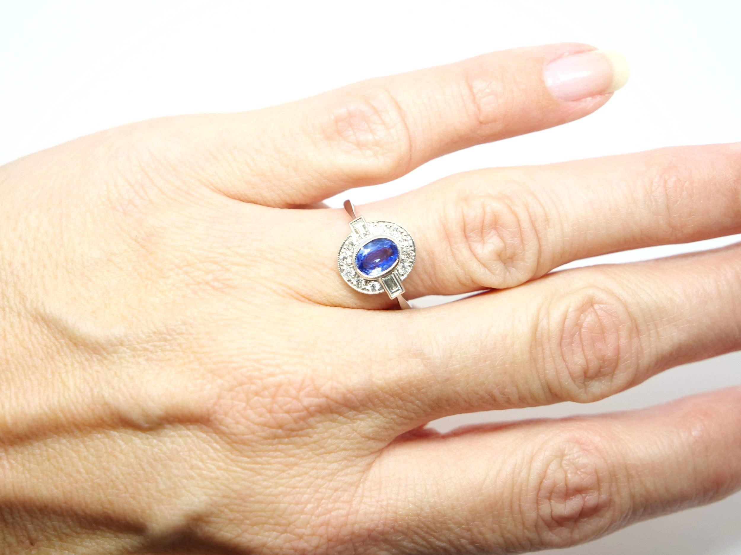 Very pretty Art Deco style platinum sapphire and diamond ring, set with an oval cut sapphire of approximately 1ct, with a baguette cut diamond to each shoulder.
