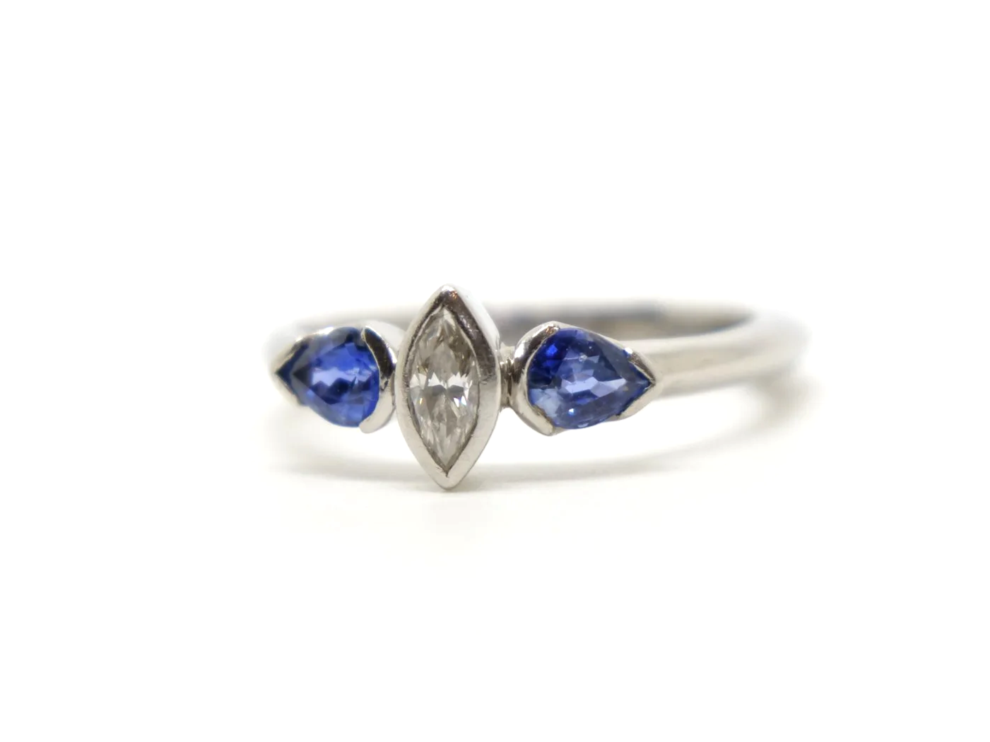 Beautiful platinum diamond and sapphire three stone ring, set with a marquise cut diamond and two pear cut sapphires.