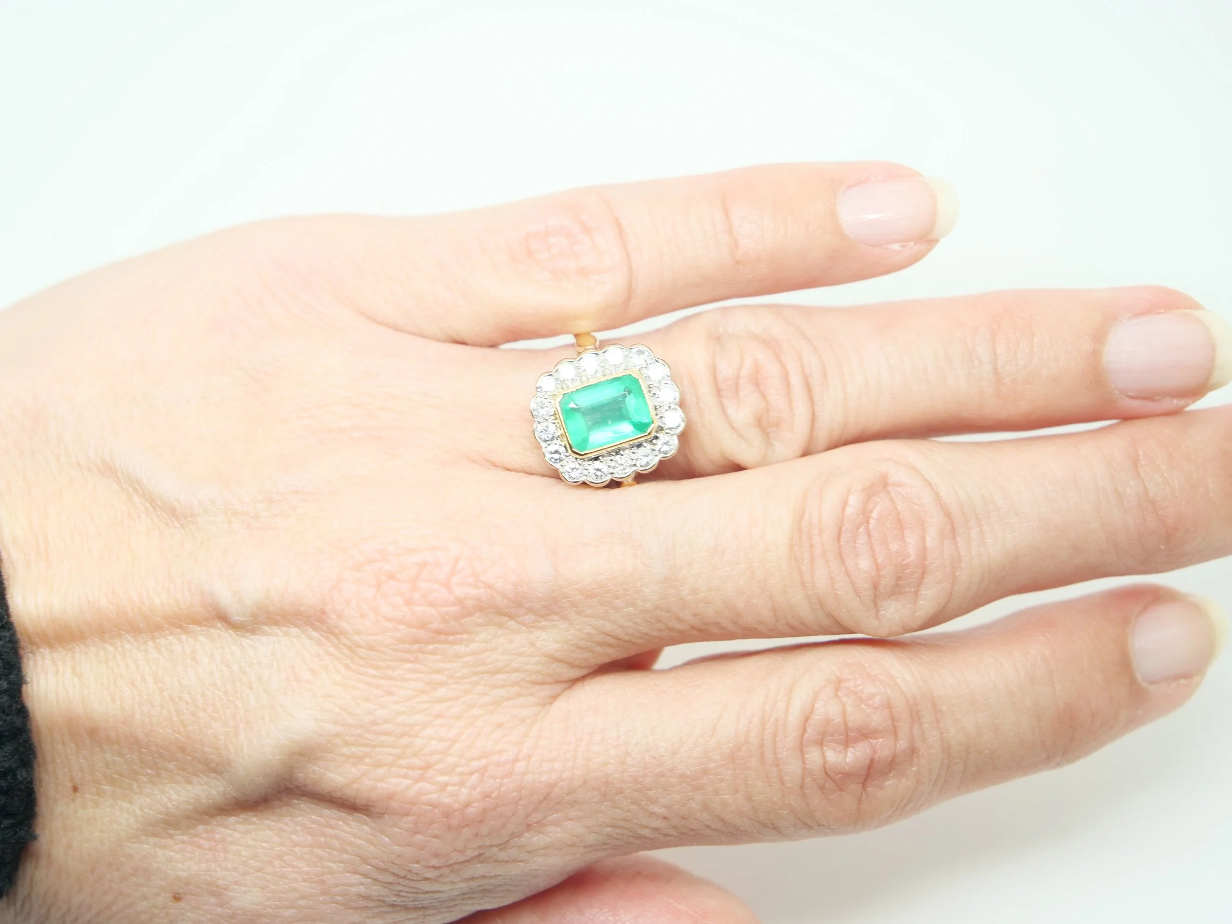 Stunning 18ct gold emerald and diamond ring, set with an emerald cut emerald of approximately 1.6ct, surrounded by brilliant cut diamonds.