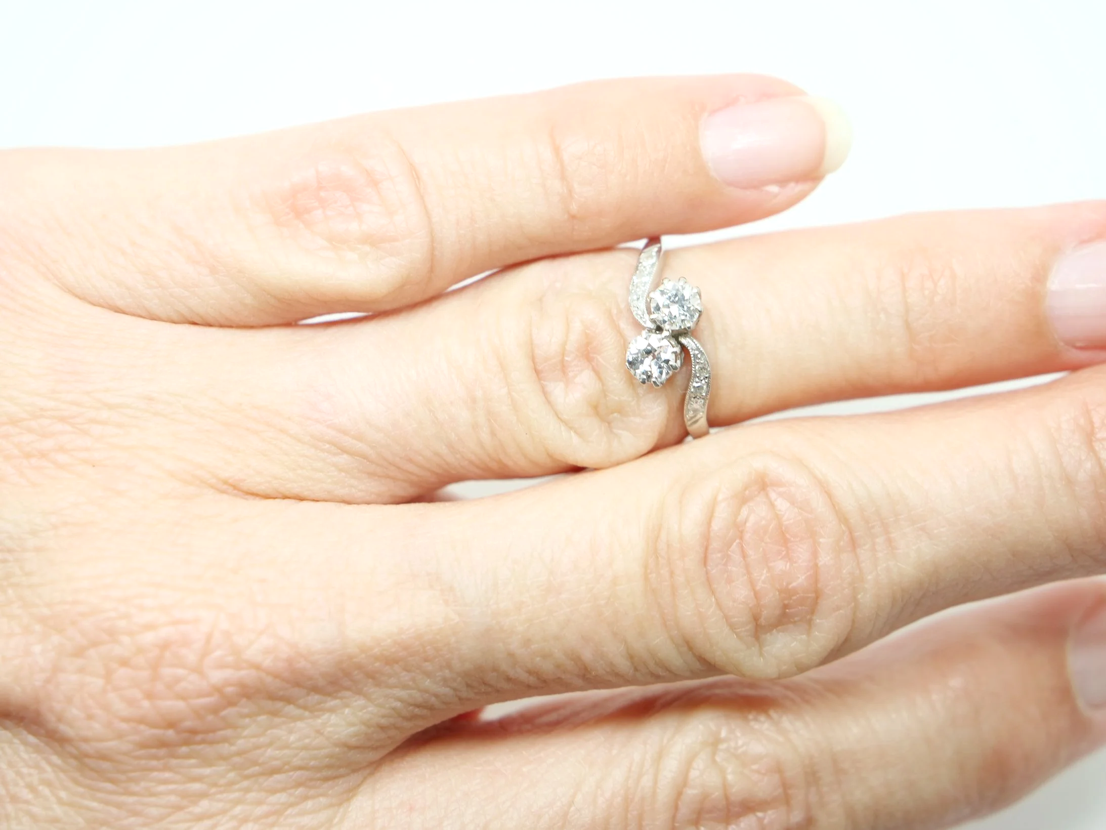 Super platinum diamond toi et moi ring, set with two old cut diamonds, with further diamonds set into each shoulder.