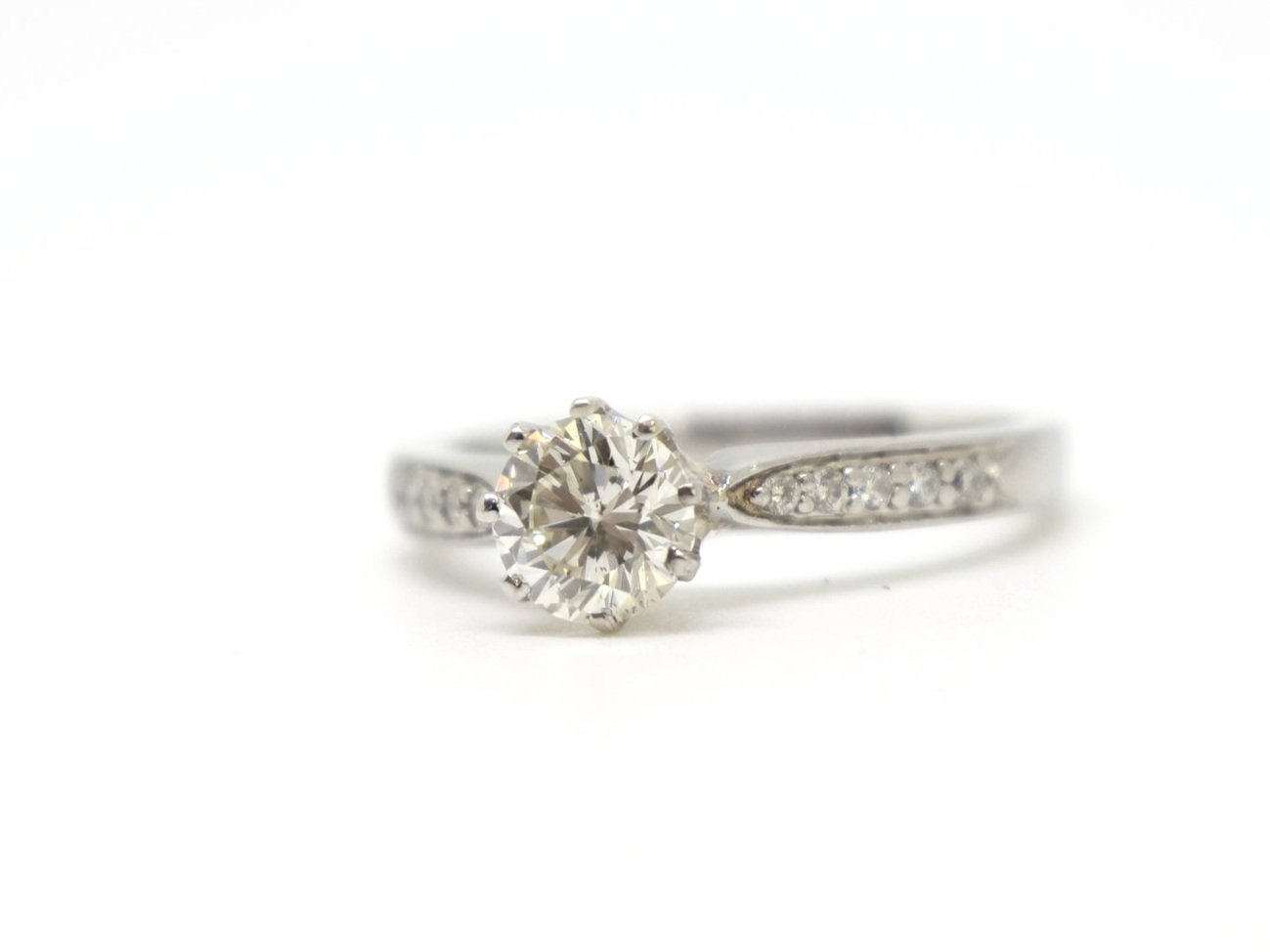Classic platinum diamond solitaire engagement ring, set with a brilliant cut central diamond of approximately 0.8ct. Further diamonds to each shoulder.