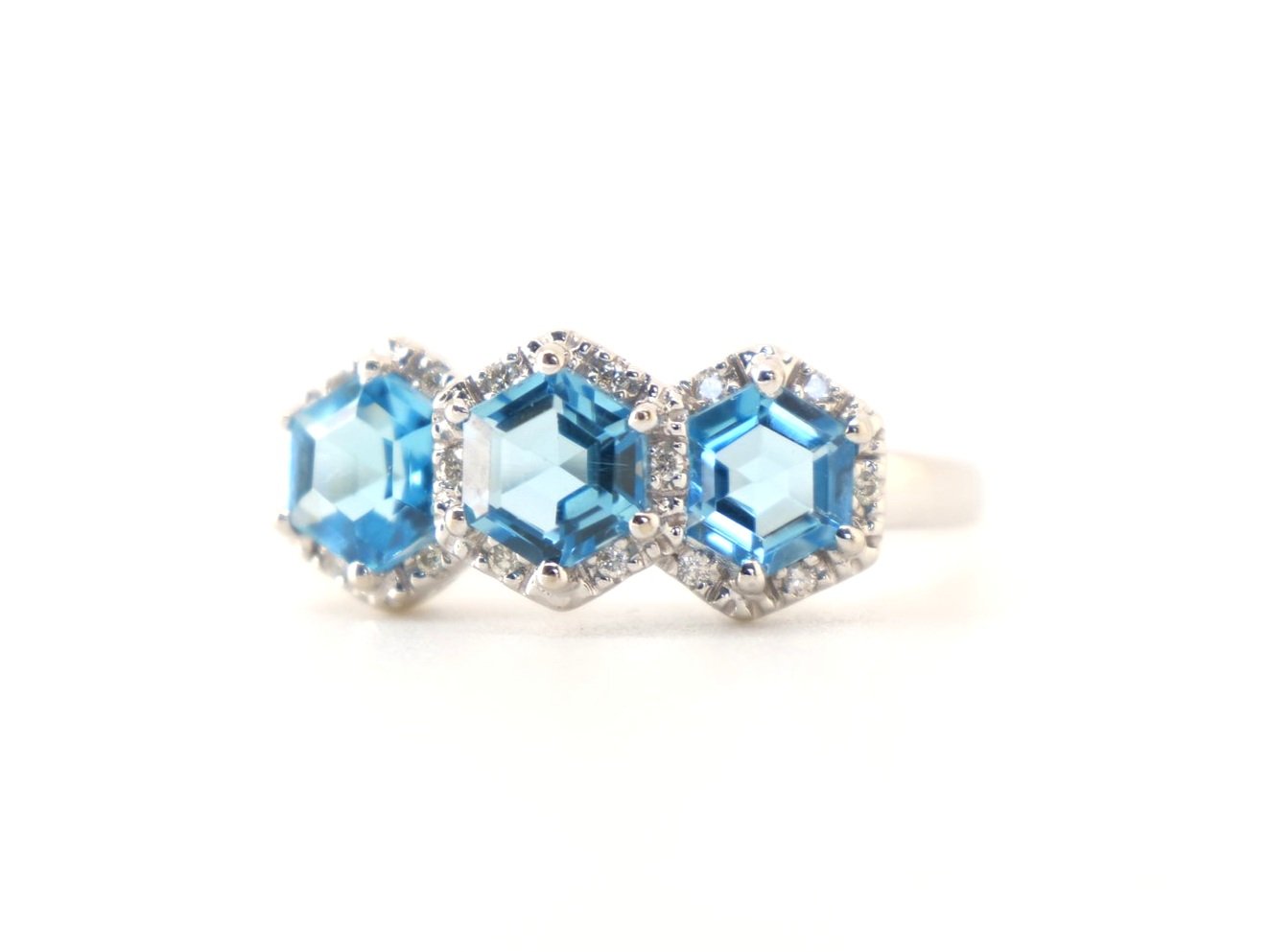 Unusual 14ct gold trilogy cocktail ring set with three hexagonal blue topaz and surrounded by diamonds.