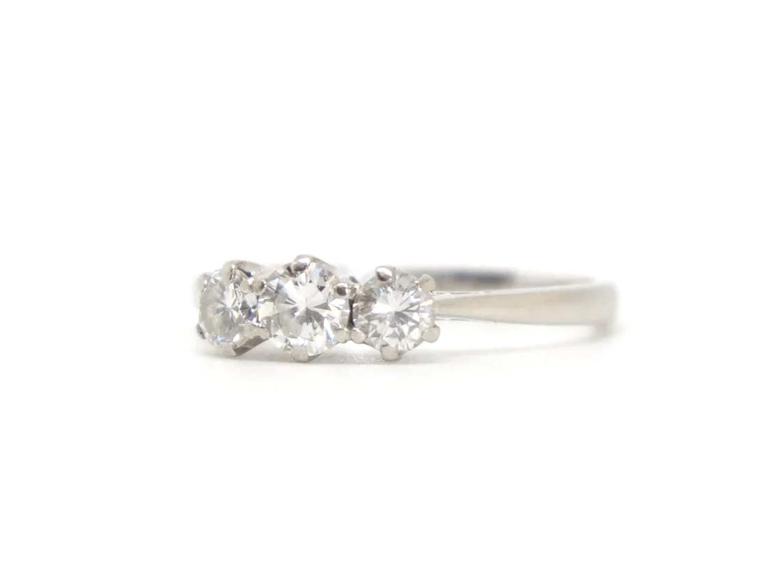 Classic platinum and diamond three stone ring, set with a larger central diamond, with a smaller diamond to each side. Approximately 0.85ct total diamonds.