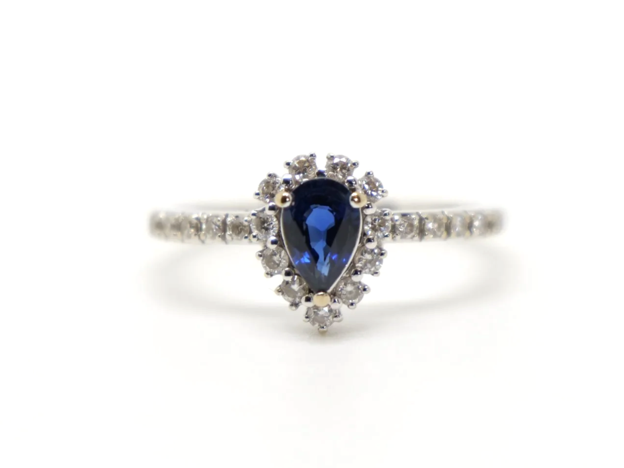 Lovely contemporary 18ct gold pear cut sapphire and diamond ring, with further diamonds set into each shoulder.
