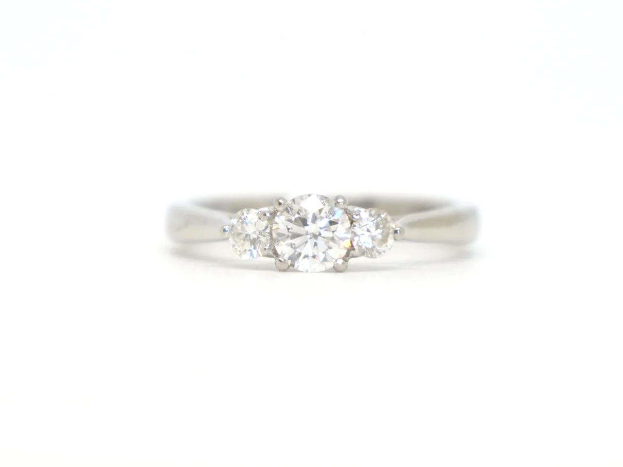 Platinum three stone diamond ring, central diamond flanked by two round diamonds