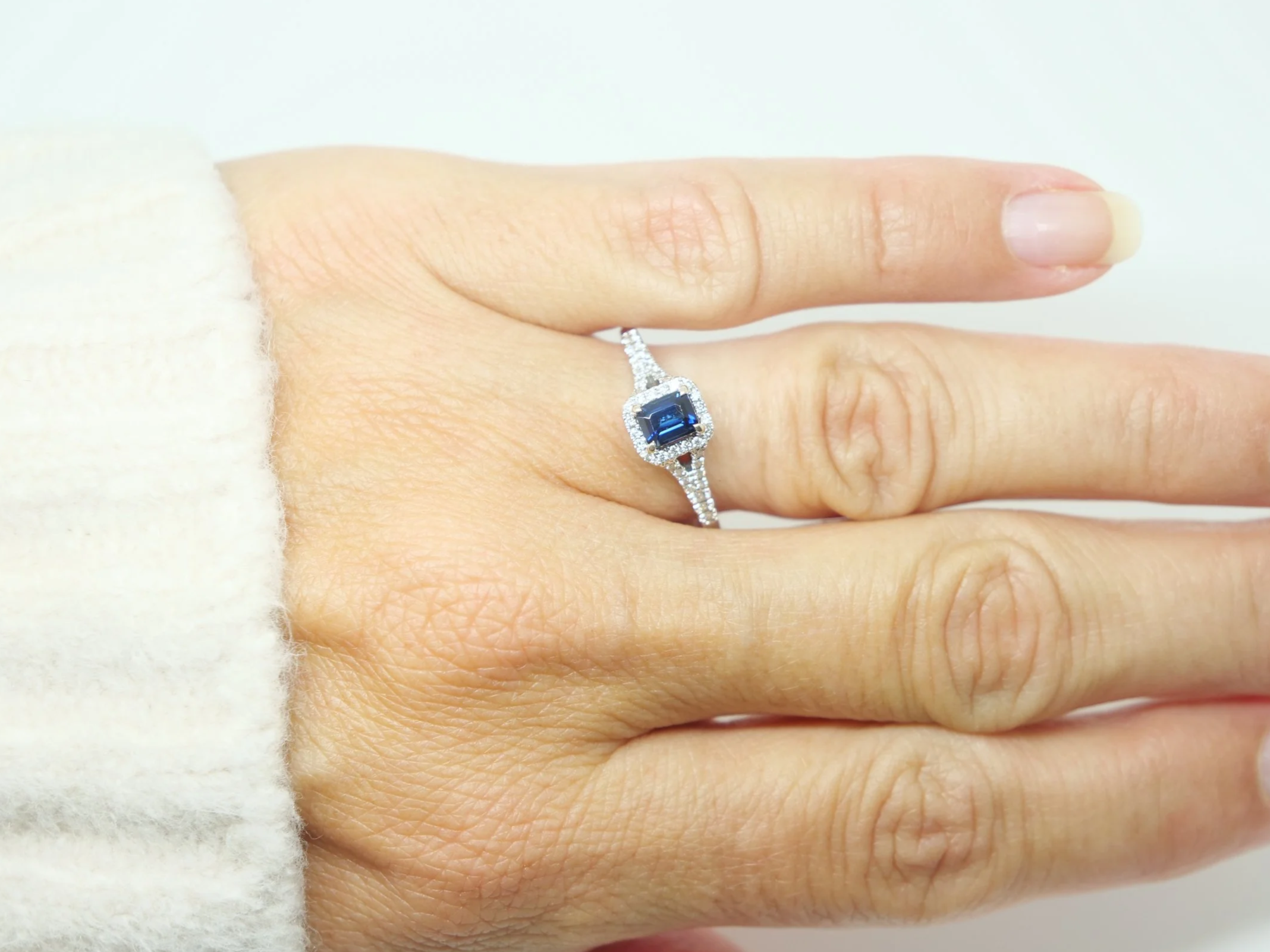 Very pretty contemporary 18ct gold sapphire and diamond ring, set with an emerald cut sapphire with diamond halo.