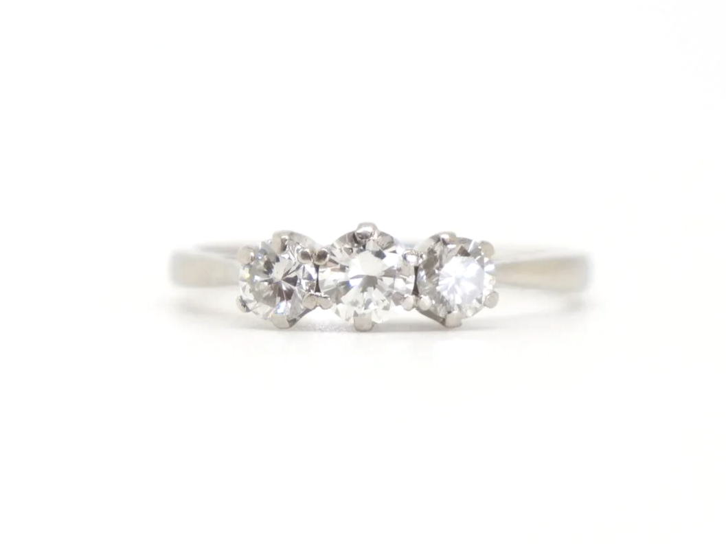 Classic platinum and diamond three stone ring, set with a larger central diamond, with a smaller diamond to each side. Approximately 0.85ct total diamonds.