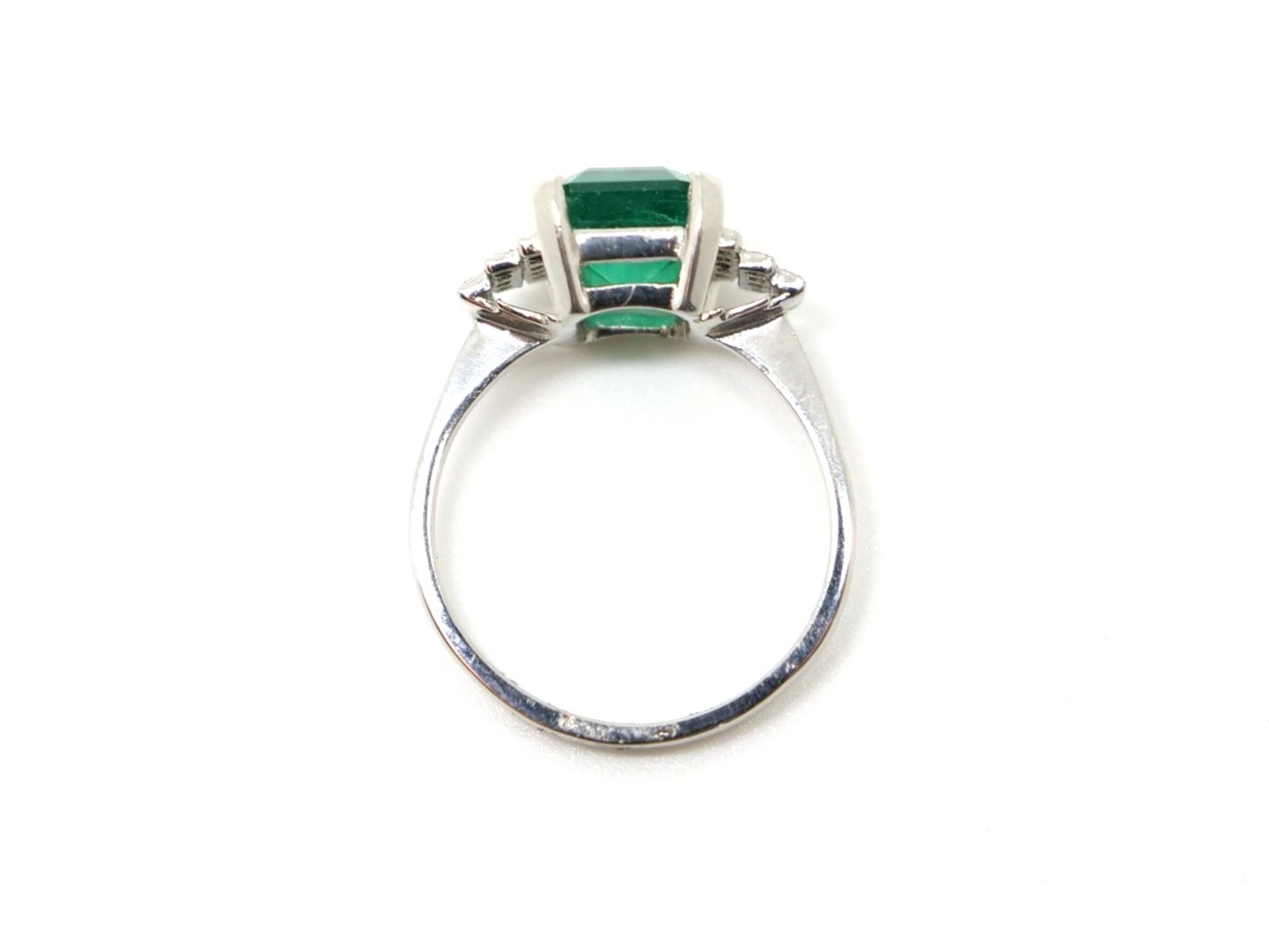 Stunning Art Deco style platinum emerald and diamond ring, set with a large approximately 3ct emerald cut emerald, with diamonds set into each shoulder.