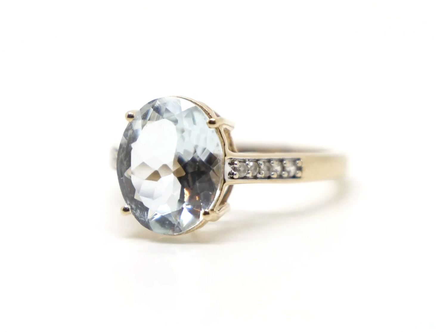Lovely 10ct gold aquamarine and diamond cocktail ring, set with a large oval cut aquamarine with small diamonds to each shoulder.