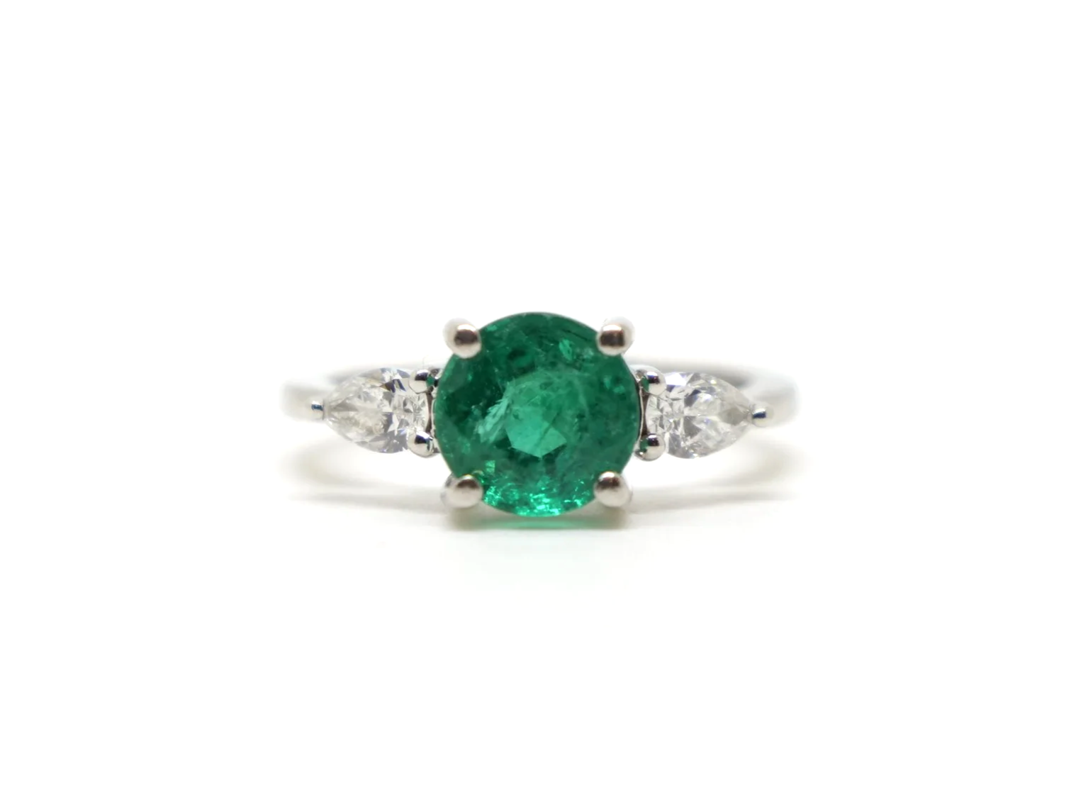 Very pretty platinum emerald and diamond ring, set with a large round cut emerald, with a pear cut diamond to each side.