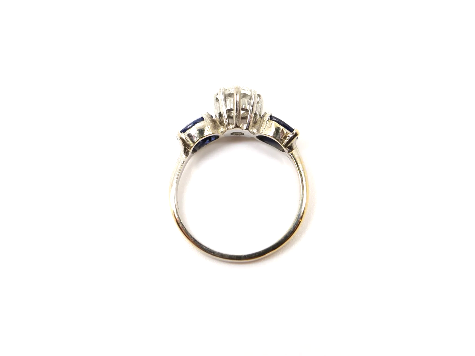 unusual vintage three stone ring in 18ct white gold with a round old cut diamond of approximately 1 carat at the centre, flanked by two oval cut sapphires of approximately 1.4 carats in total.